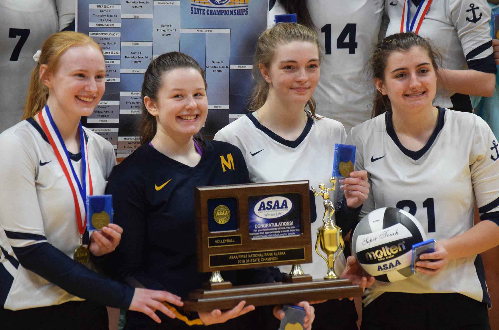 Members of the Homer volleyball team hold up the Class 3A state championship trophy Saturday, Nov. 16, 2019, at the Class 3A state volleyball tournament at the Alaska Airlines Center in Anchorage, Alaska. (Photo by Joey Klecka/Peninsula Clarion)
