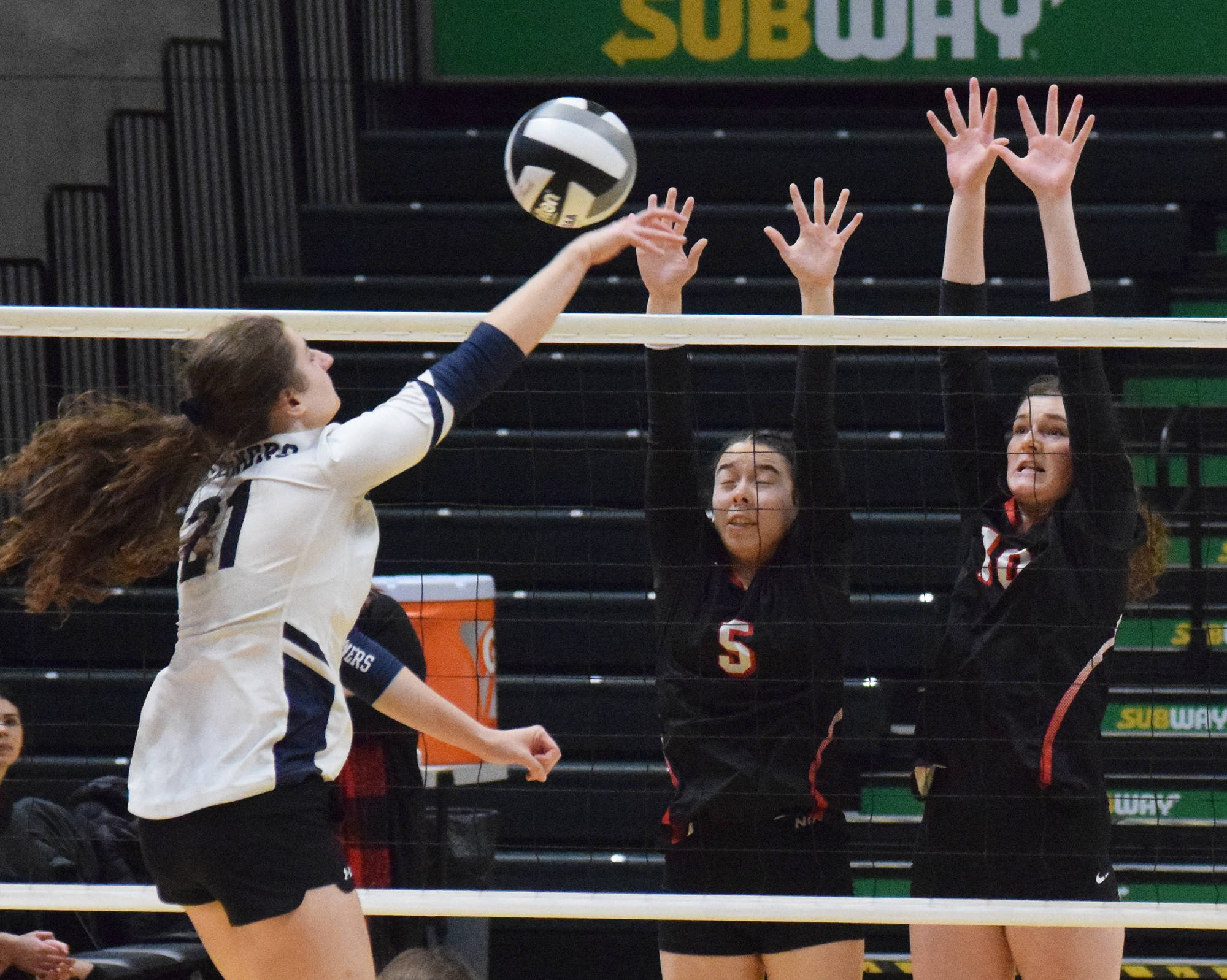 Kenai’s Chelsea Plagge (left) and Abby Every team up for a block on Homer’s Marina Carroll, Saturday, Nov. 16, 2019, at the Class 3A state volleyball tournament at the Alaska Airlines Center in Anchorage, Alaska. (Photo by Joey Klecka/Peninsula Clarion)