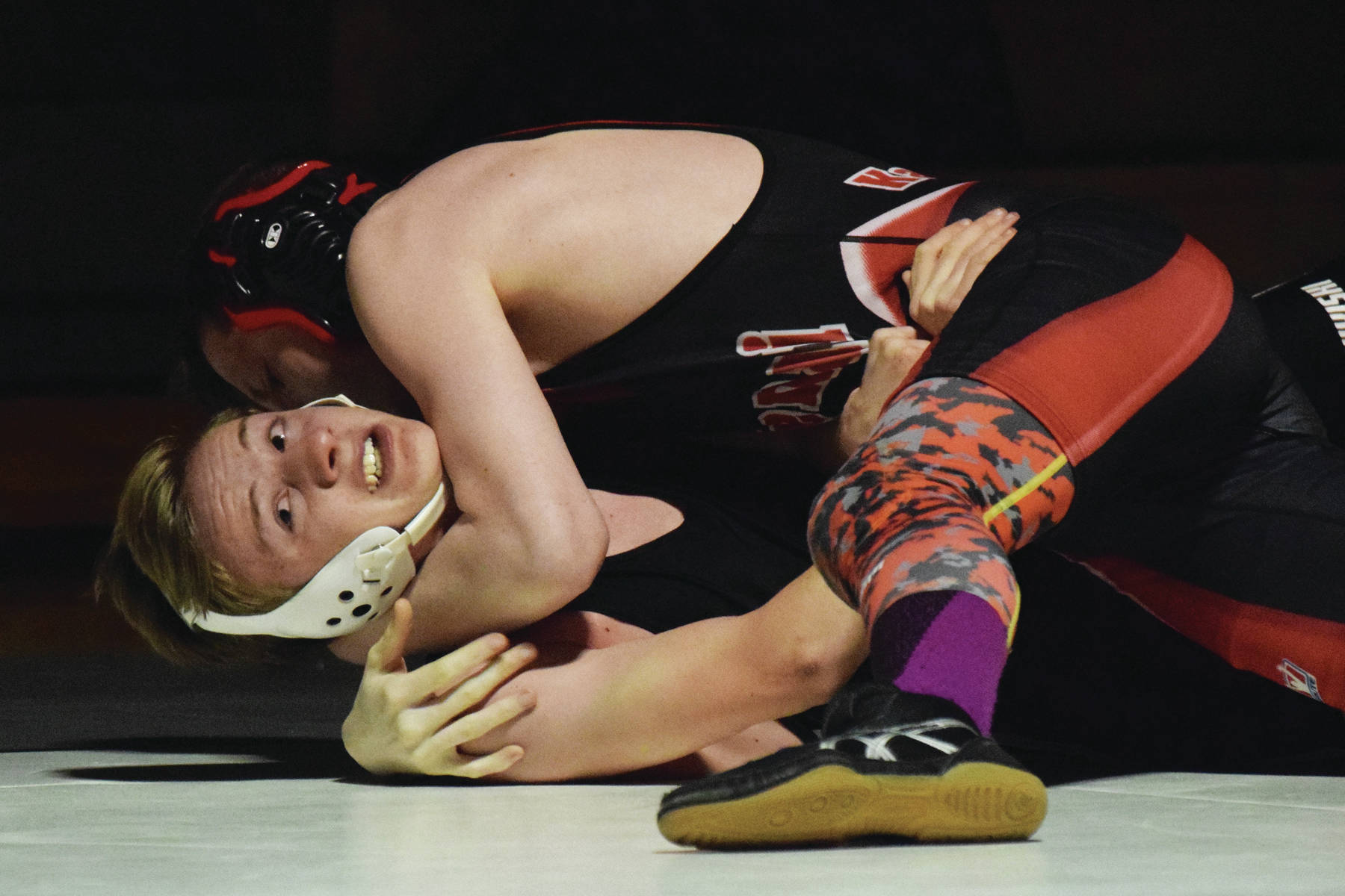 Nikiski’s Yorik Bastuck attempts to slip out of a hold by Kenai’s Isaiah Ticknor, Tuesday, Nov. 19, 2019, at a Kenai/Nikiski dual meet at Nikiski High School. (Photo by Joey Klecka/Peninsula Clarion)