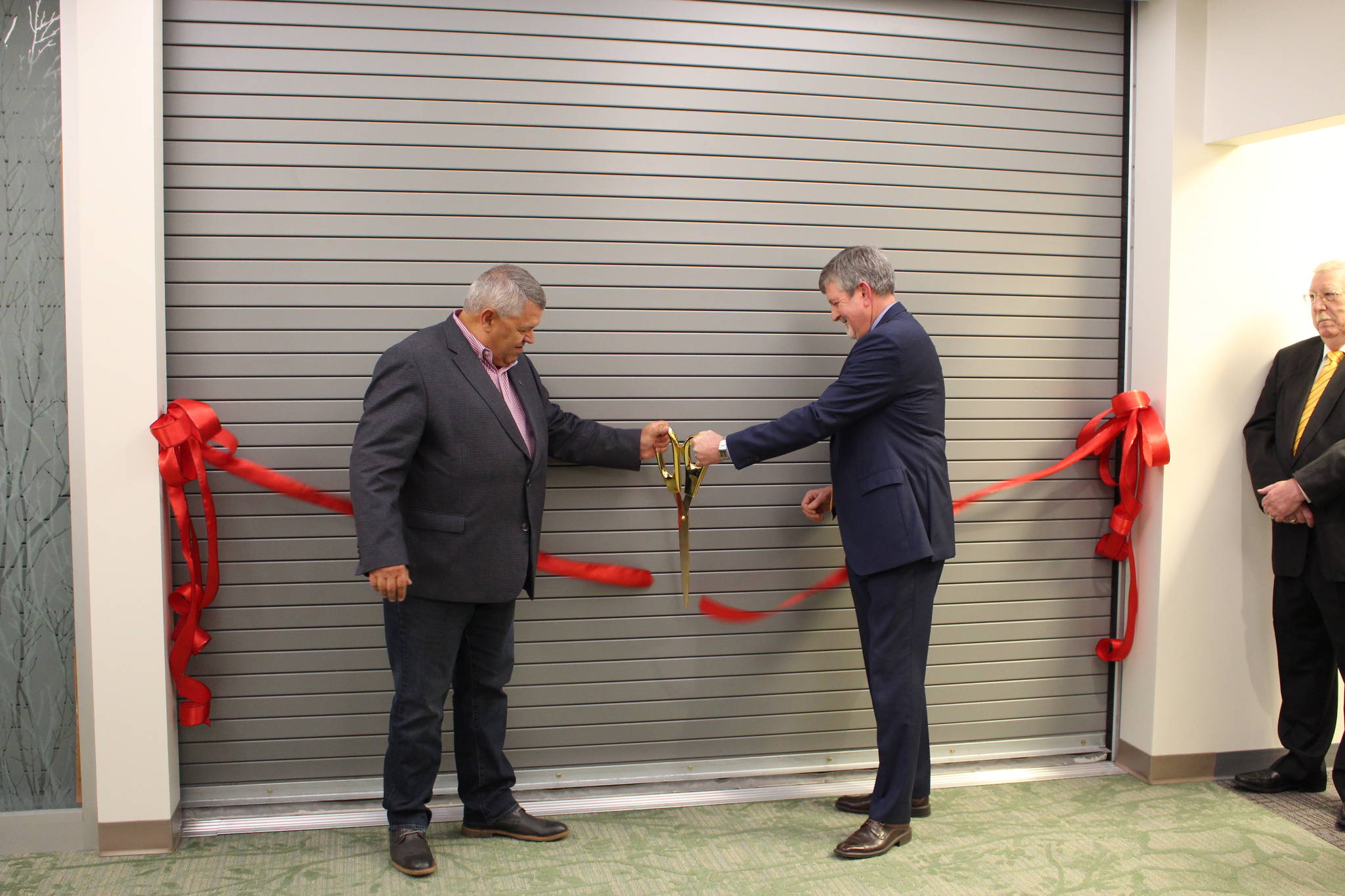 Kenai Peninsula Borough Mayor Charlie Pierce, left, and Central Peninsula Hospital CEO Rick Davis, right, cut the ribbon leading to the new wing of the hospital in Soldotna, Alaska on Nov. 20, 2019. (Photo by Brian Mazurek/Peninsula Clarion)