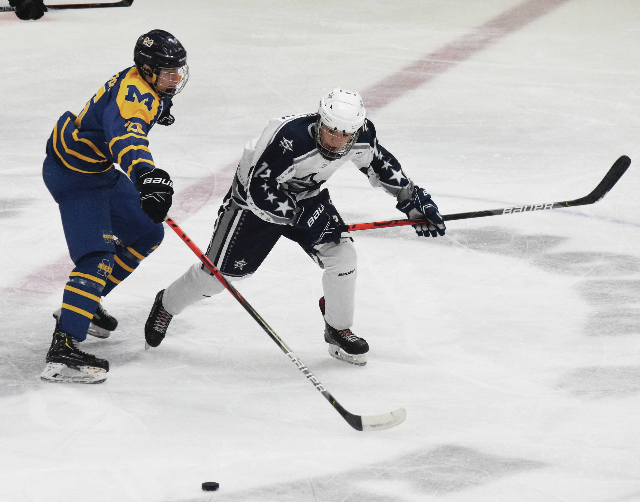 Soldotna’s Aiden Burcham battles for the puck with Homer’s Ethan Pitzman, Friday, Nov. 22, 2019, at the Soldotna Regional Sports Complex in Soldotna, Alaska. (Photo by Joey Klecka/Peninsula Clarion)