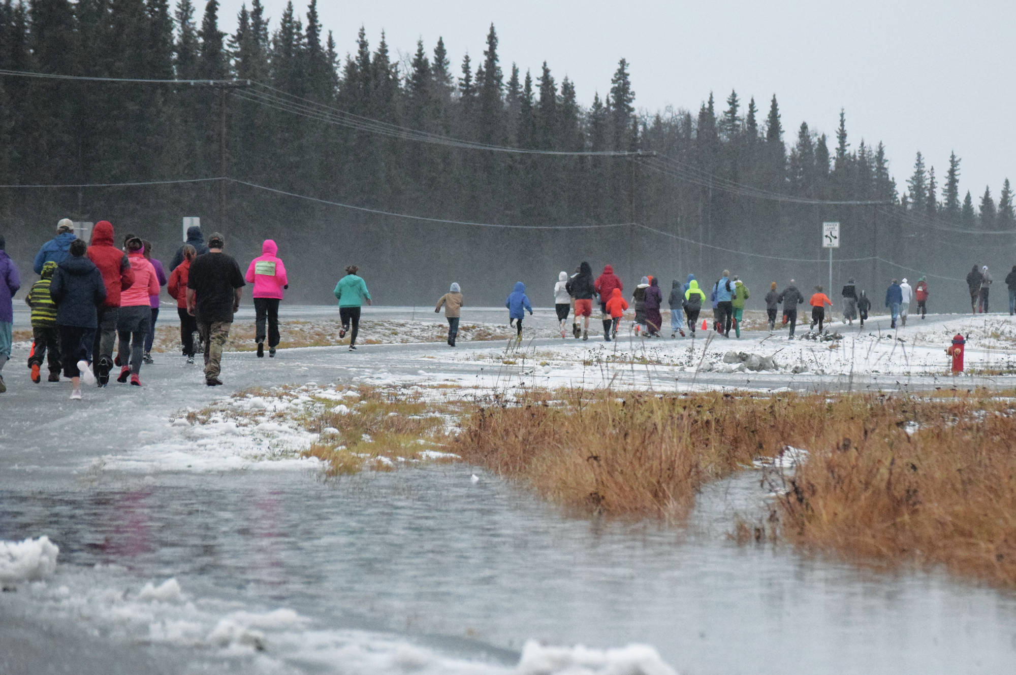 The field of runners make their way down the Unity Trail early on Thursday, Nov. 28, 2019, at the Turkey Trot in Soldotna, Alaska. (Photo by Joey Klecka/Peninsula Clarion)