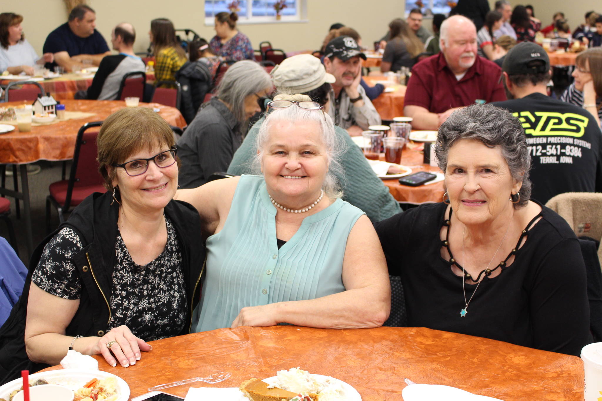 From left, Diane Somers, Cindy Todd and Barbara Cooper smile for the camera during the Thanksgiving community potluck at College Heights Baptist Church in Soldotna, Alaska, on Thursday, Nov. 28, 2019. (Photo by Brian Mazurek/Peninsula Clarion)