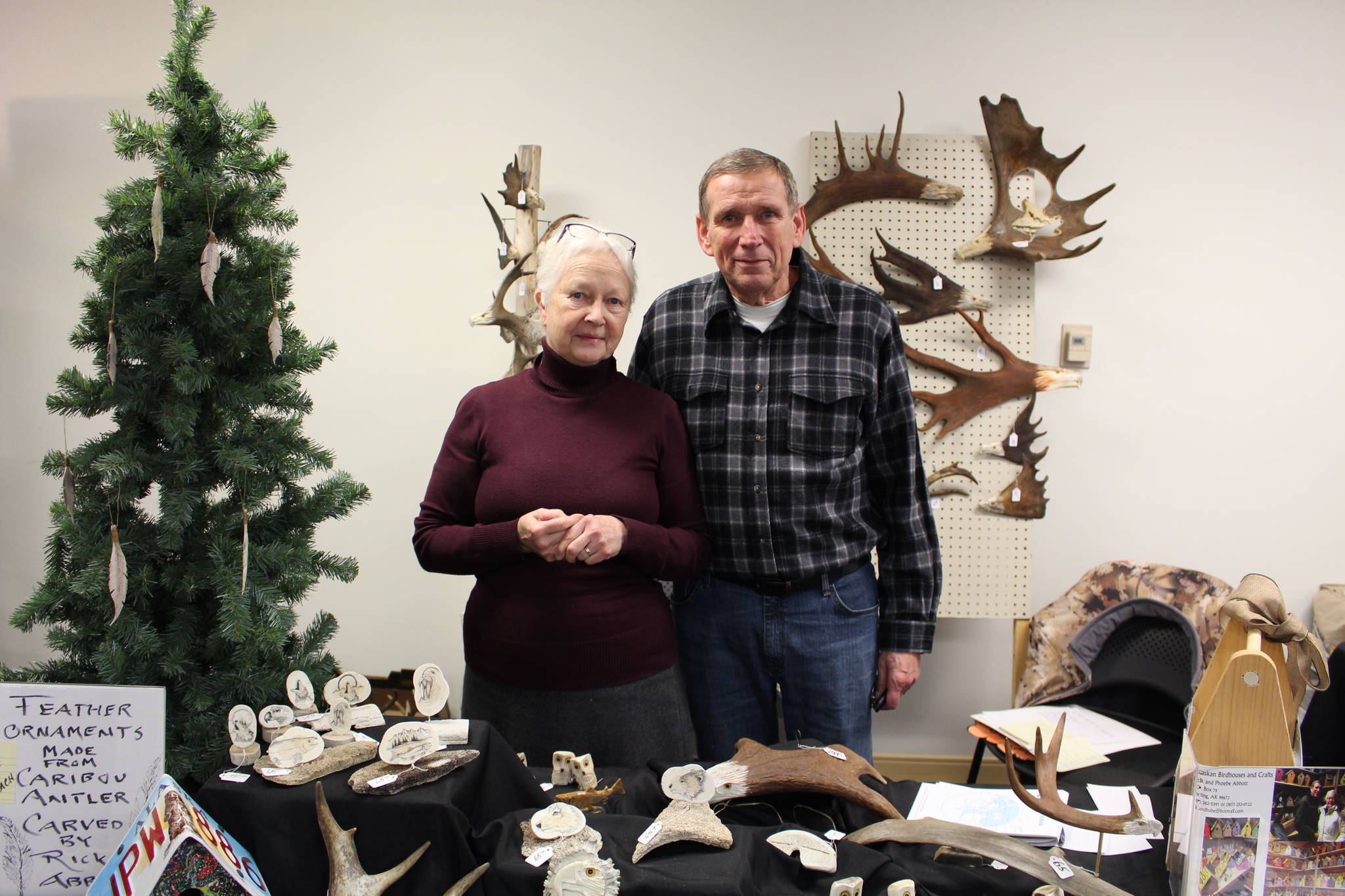 Phoebe and Rick Abbott, owners of Alaskan Birdhouses and Crafts, display some of their carvings for sale at the annual Central Peninsula Hospital Auxiliary Holiday Bazaar in Soldotna, Alaska on Dec. 6, 2019. (Photo by Brian Mazurek/Peninsula Clarion)