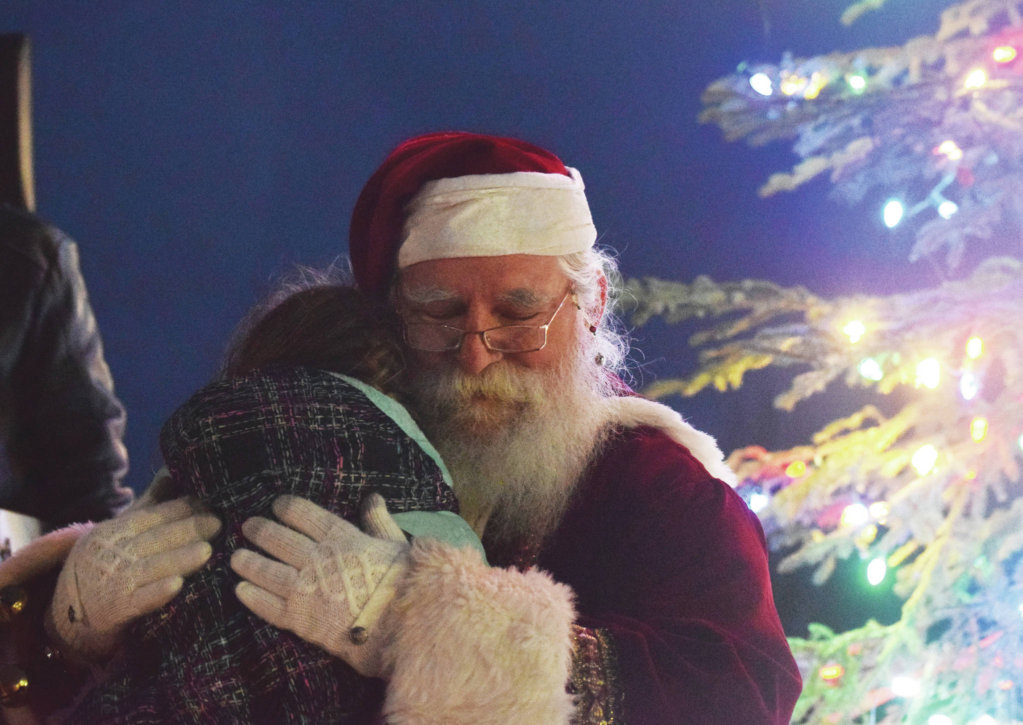 Santa Claus gives a young girl a hug Saturday, Dec. 7, 2019, at the Christmas in the Park celebration at Soldotna Creek Park in Soldotna, Alaska. (Photo by Joey Klecka/Peninsula Clarion)