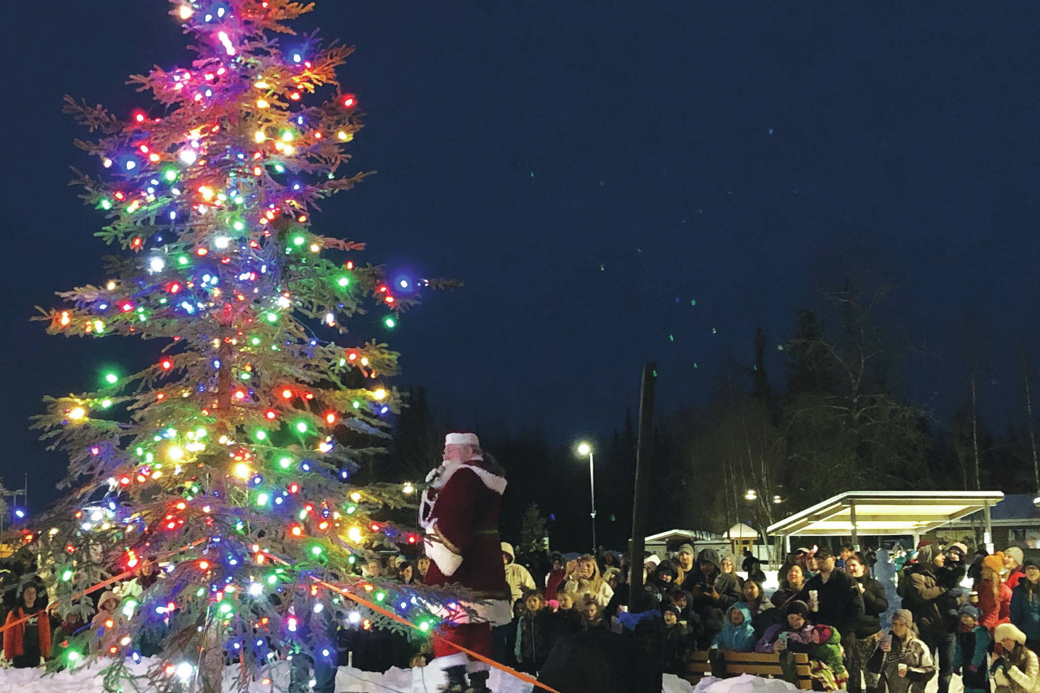 Santa Claus lights up the Christmas tree in front of an audience Saturday, Dec. 7, 2019, at the Christmas in the Park Celebration at Soldotna Creek Park in Soldotna, Alaska. (Photo by Joey Klecka/Peninsula Clarion)