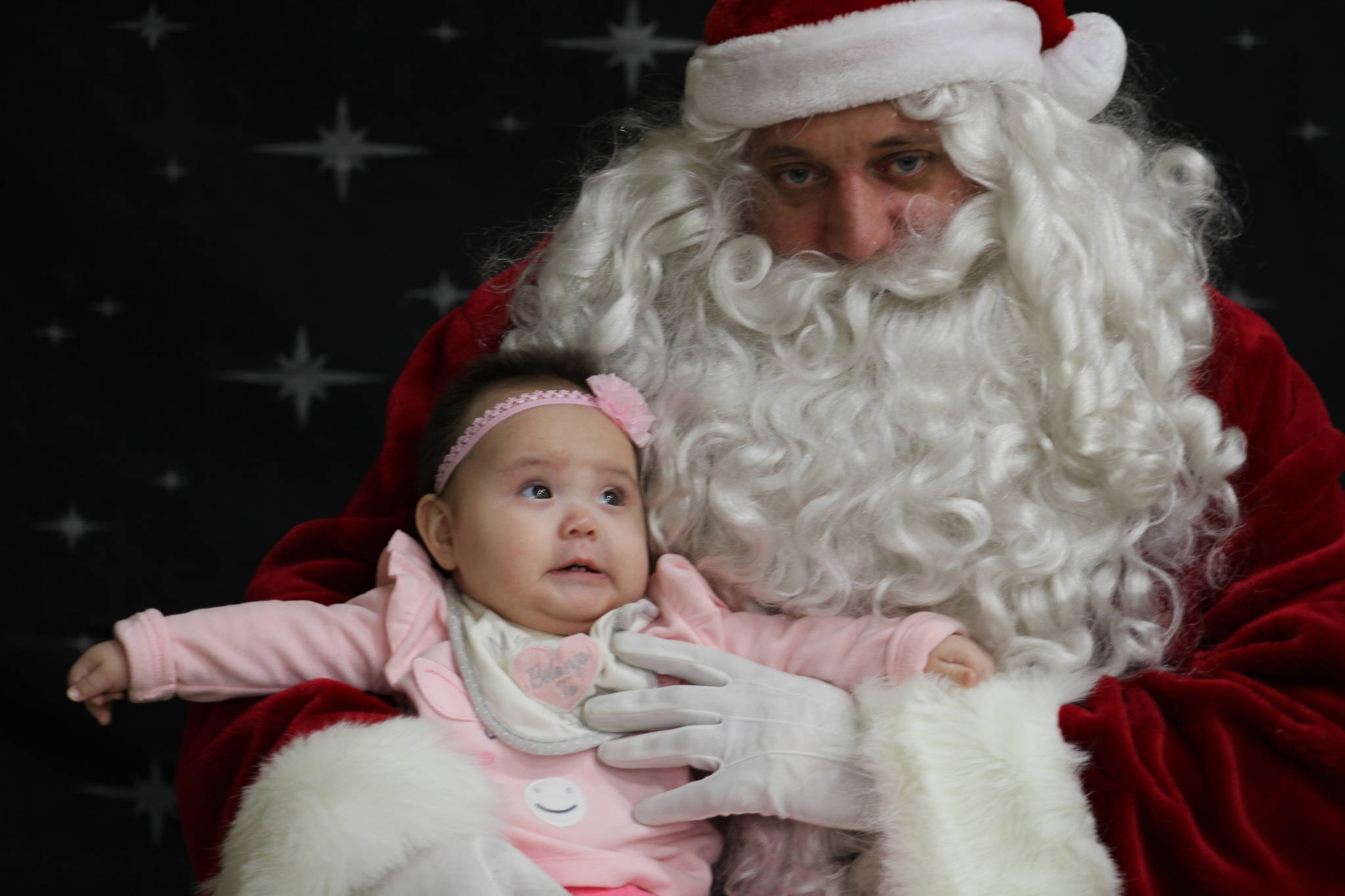This Dec. 3, 2019, photo shows 6-month-old Rebecca Ilmar having her photo taken with Santa Claus in Napakiak, Alaska. The Alaska National Guard brought its Operation Santa Claus to the western Alaska community, which is being severely eroded by the nearby Kuskokwim River. (AP Photo/Mark Thiessen)
