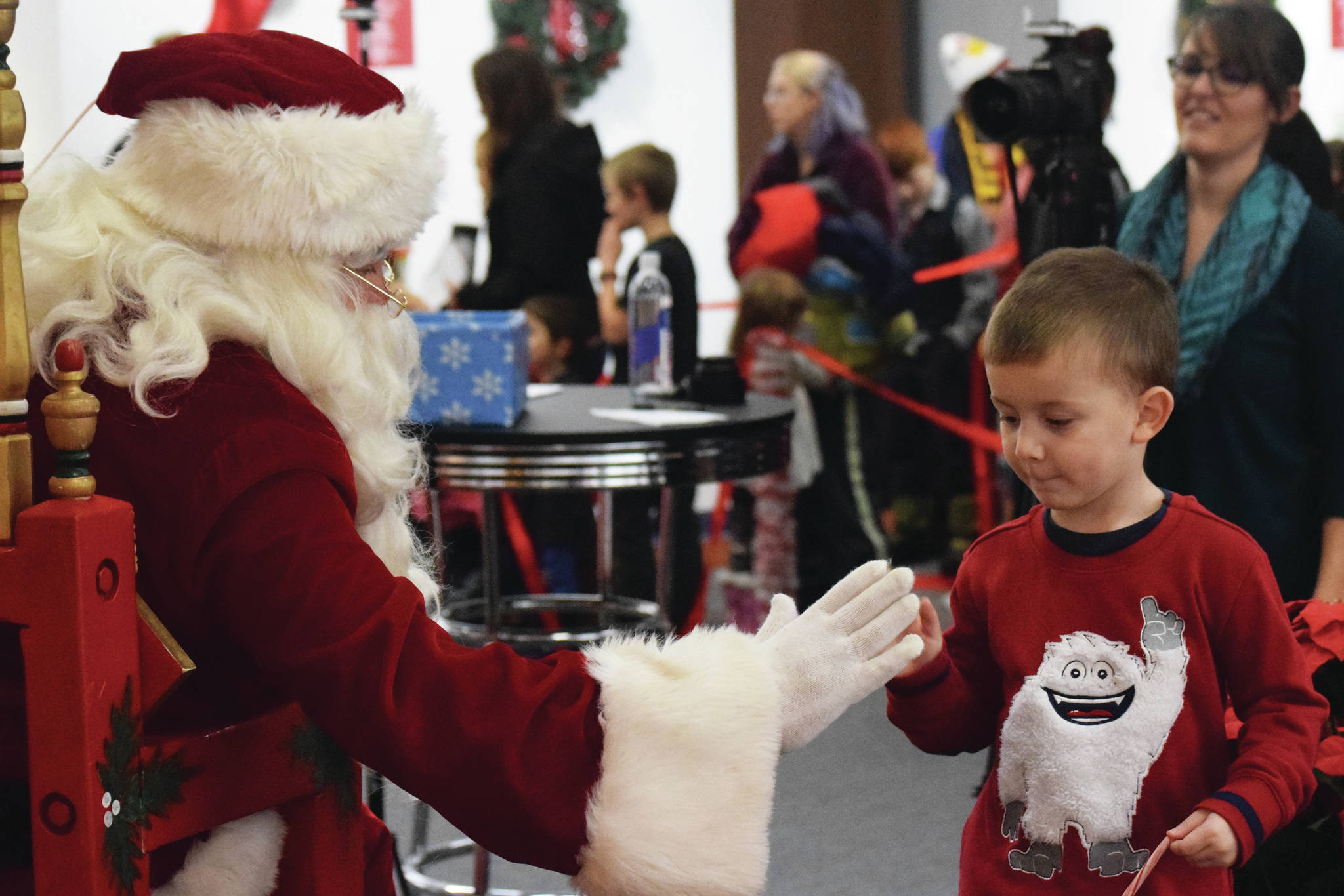 Joey Klecka / Peninsula Clarion                                Santa Claus gives a young fan a high five Nov. 29 at the Christmas Comes to Kenai celebration at the Kenai Visitor and Cultural Center.
