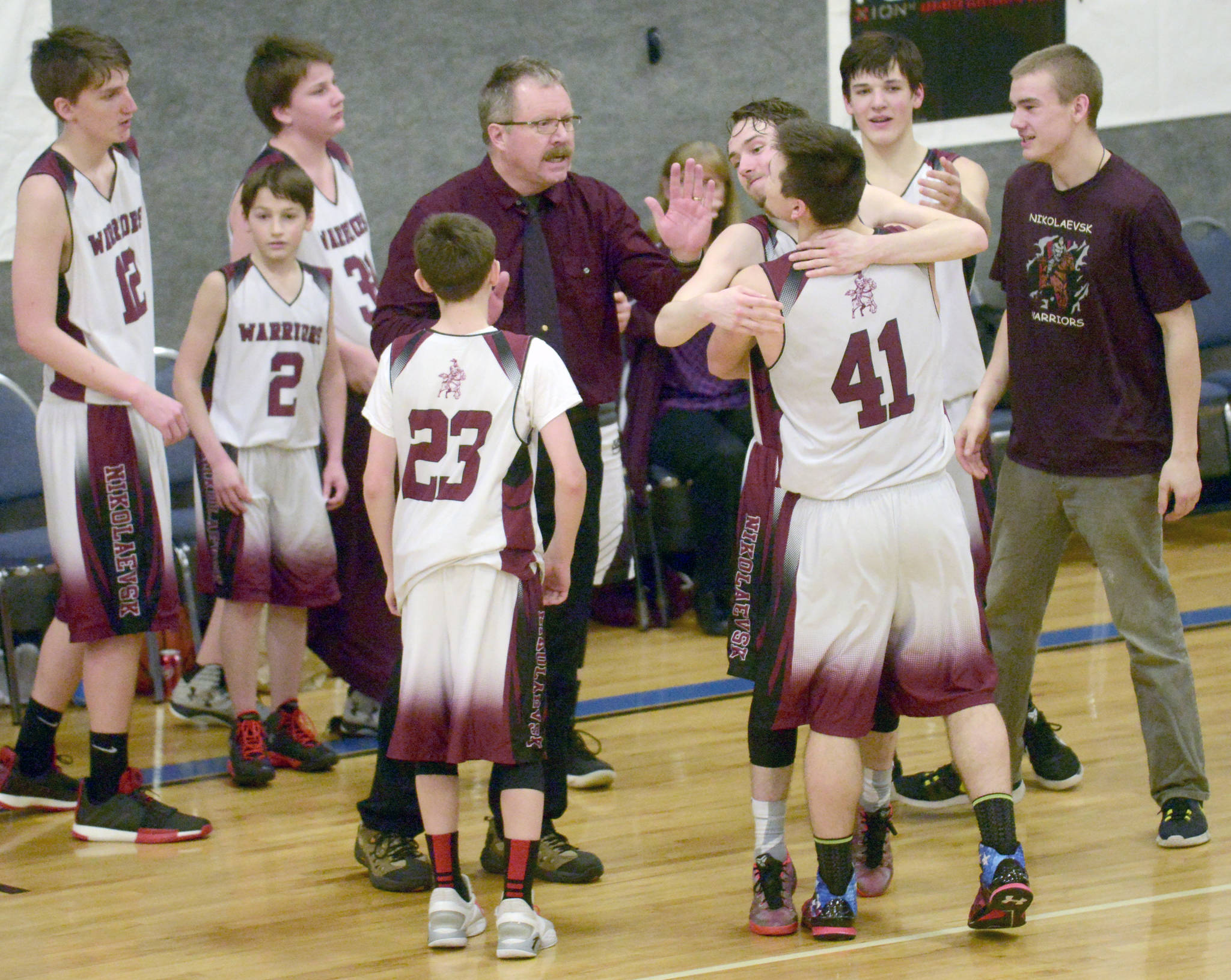 Nikolaevsk coach Steve Klaich celebrates with his team after winning his first Peninsula Conference title in his 30th season at the helm at Cook Inlet Academy in Soldotna. (Photo by Jeff Helminiak/Peninsula Clarion)