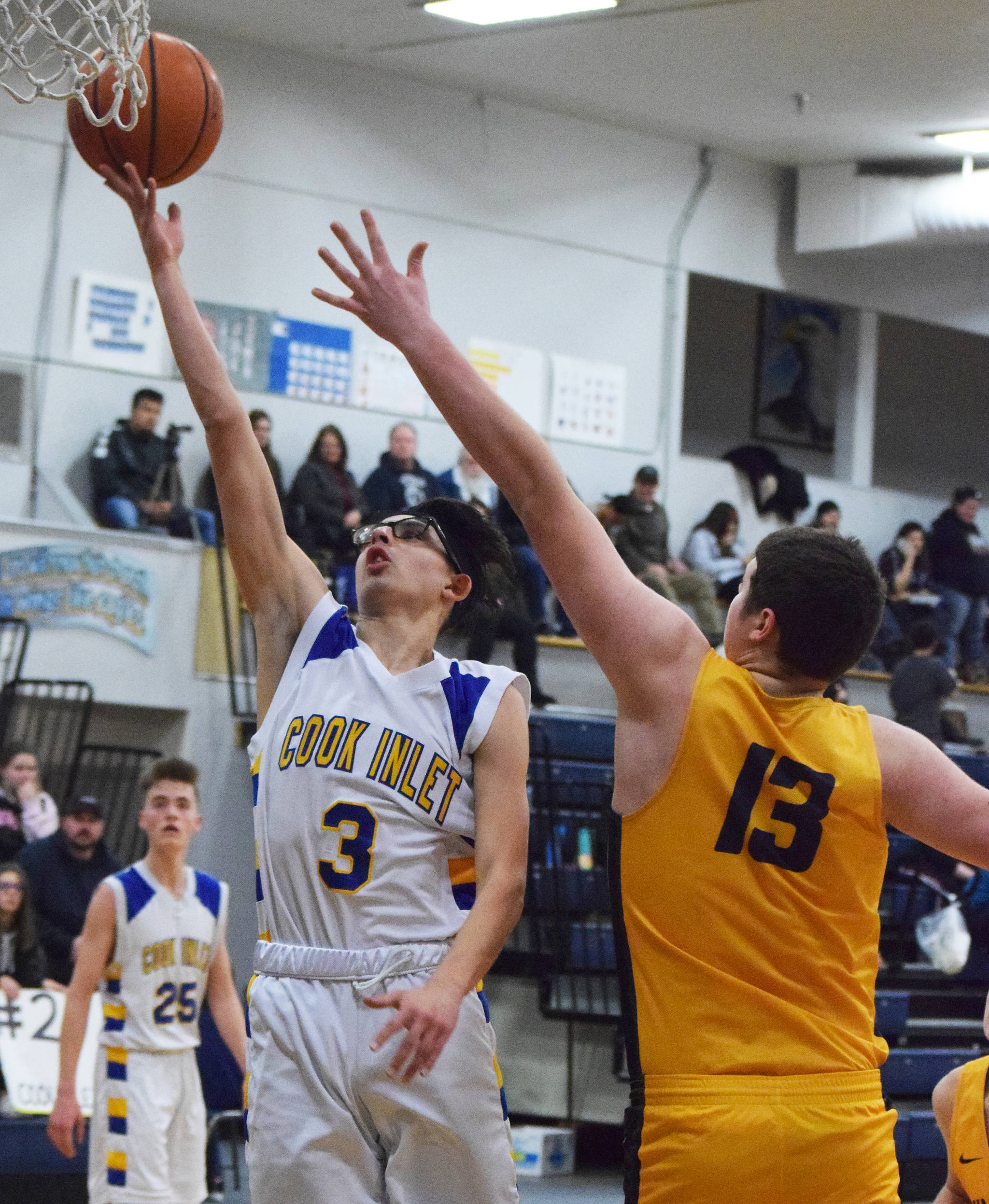 CIA’s Austin Matheson (3) gets past a block by Ninilchik’s Jake Clark, Tuesday, Jan. 7, 2020, at Cook Inlet Academy in Soldotna, Alaska. (Photo by Joey Klecka/Peninsula Clarion)