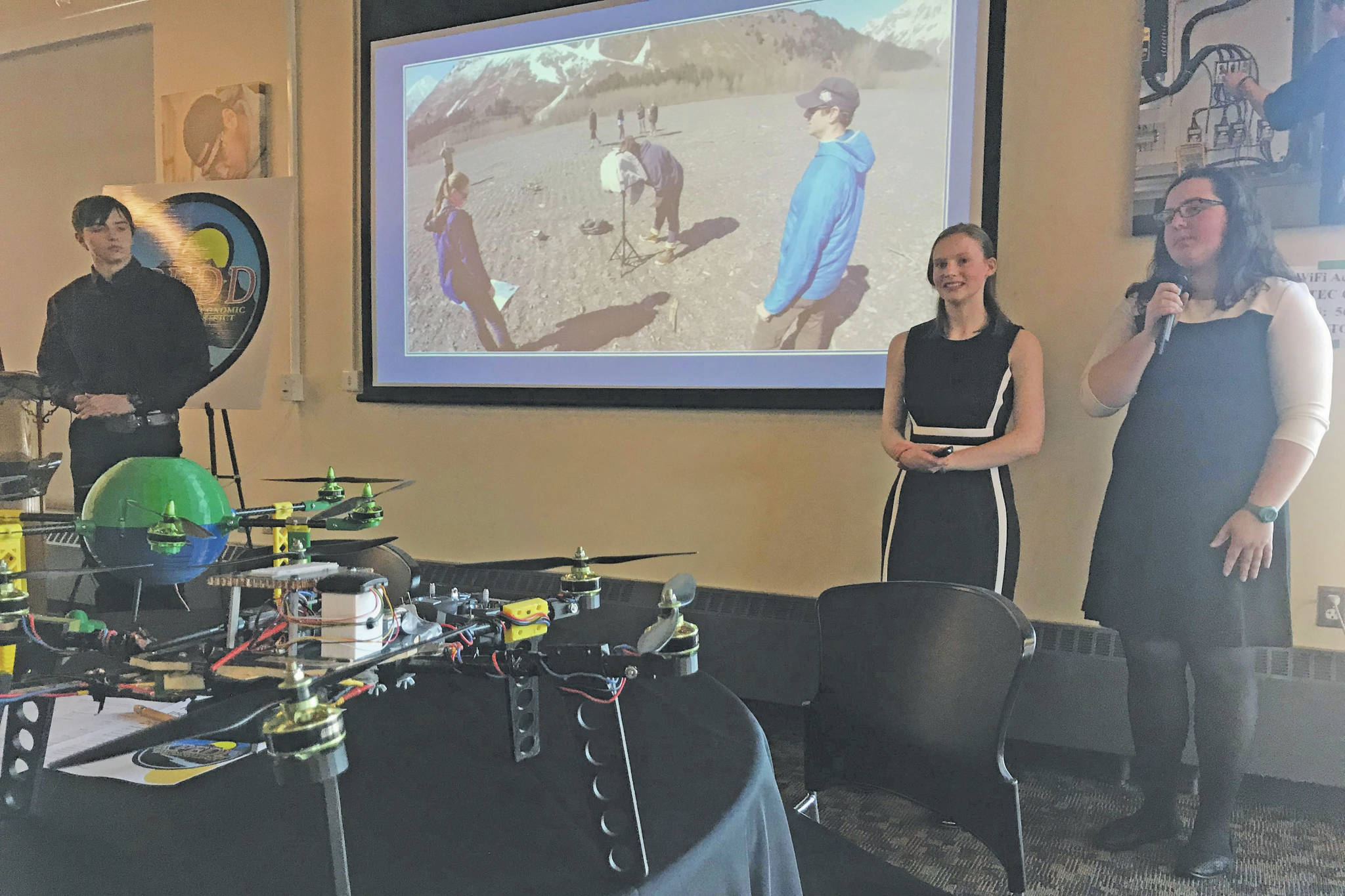 Seward High School students (from left) Tayten Barhaug, Lindy Guernsey and Akilena Veach demonstrate their Caring for the Kenai project, drones to help map the flood planes of Seward, during the Industry Outlook Forum in Seward on Wednesday. (Photo by Kat Sorensen/Peninsula Clarion)
