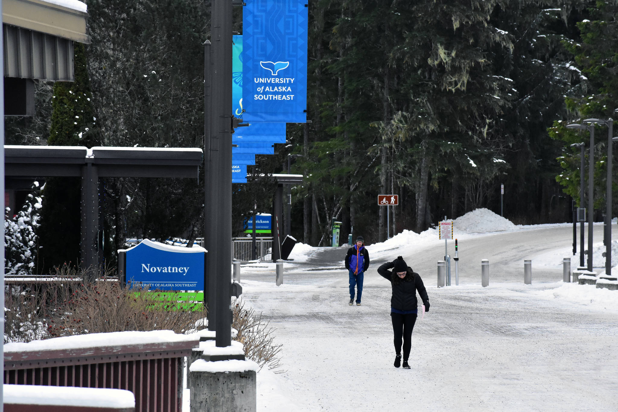 A student fixes her hood as she walks across the campus at the University of Alaska Southeast on Thursday, Jan. 16, 2020. (Peter Segall | Juneau Empire)
