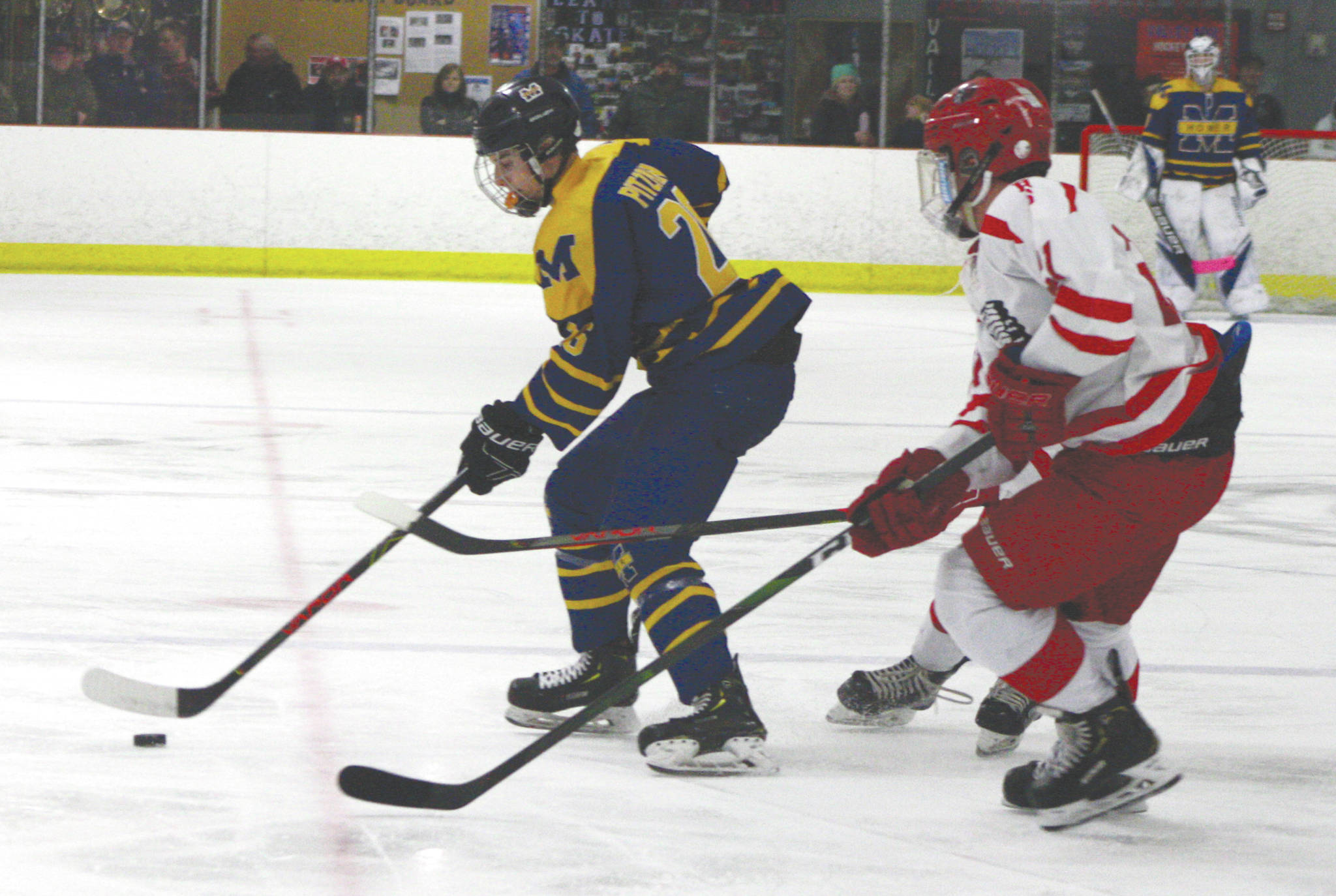 Homer’s Ethan Pitzman skates the puck away from a pair of defenders during a game against Wasilla Thursday, Jan. 23, 2020, in Wasilla. (Photo by Jeremiah Bartz/Frontiersman)