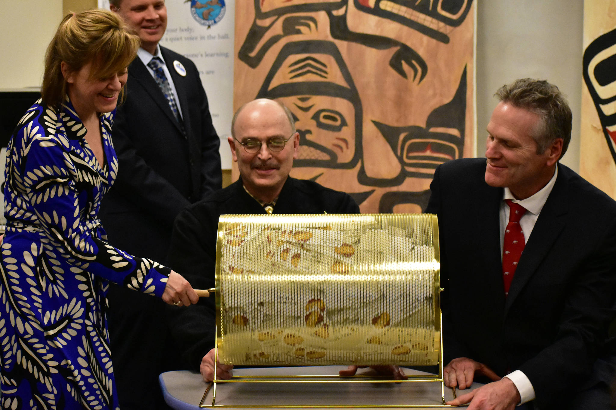 Peter Segall | Juneau Empire                                State Sen. Mia Costello, R-Anchorage, turns a tumbler full of names for the state’s first-ever Permanent Fund Dividend Raffle on Tuesday at Harborview Elementary School while Sen. Click Bishop, R-Fairbanks, and Gov. Mike Dunleavy hold the tumbler down.