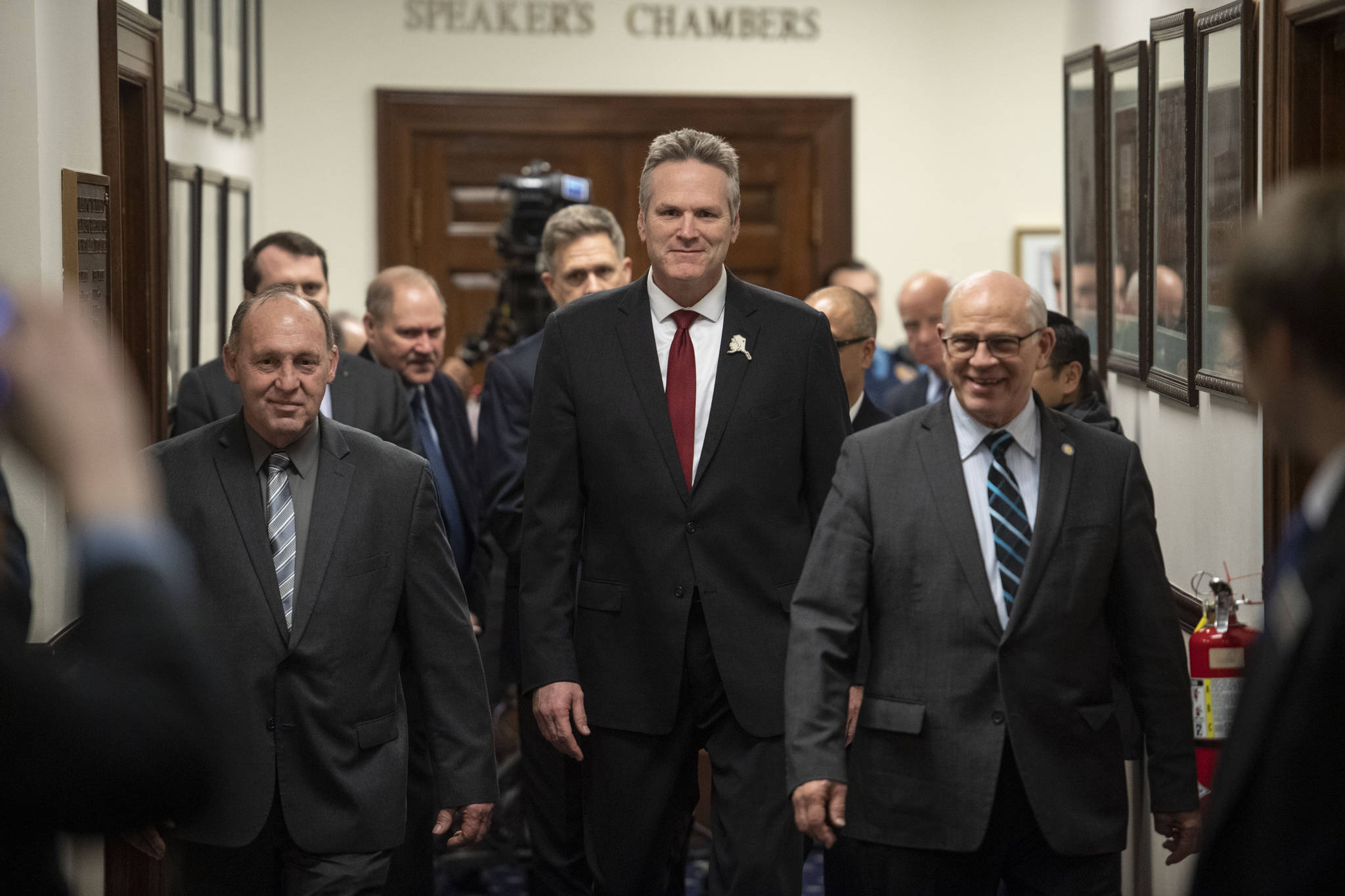 Sen. John Coghill, R-North Pole, right, and Rep. Gary Knopp, R-Kenai, left, escort Gov. Mike Dunleavy to the House chambers to deliver his State of the State speech to a Joint Session of the Alaska Legislature at the Alaska State Capitol in Juneau, Alaska, on Monday, Jan. 27, 2020. (AP Photo/Michael Penn)
