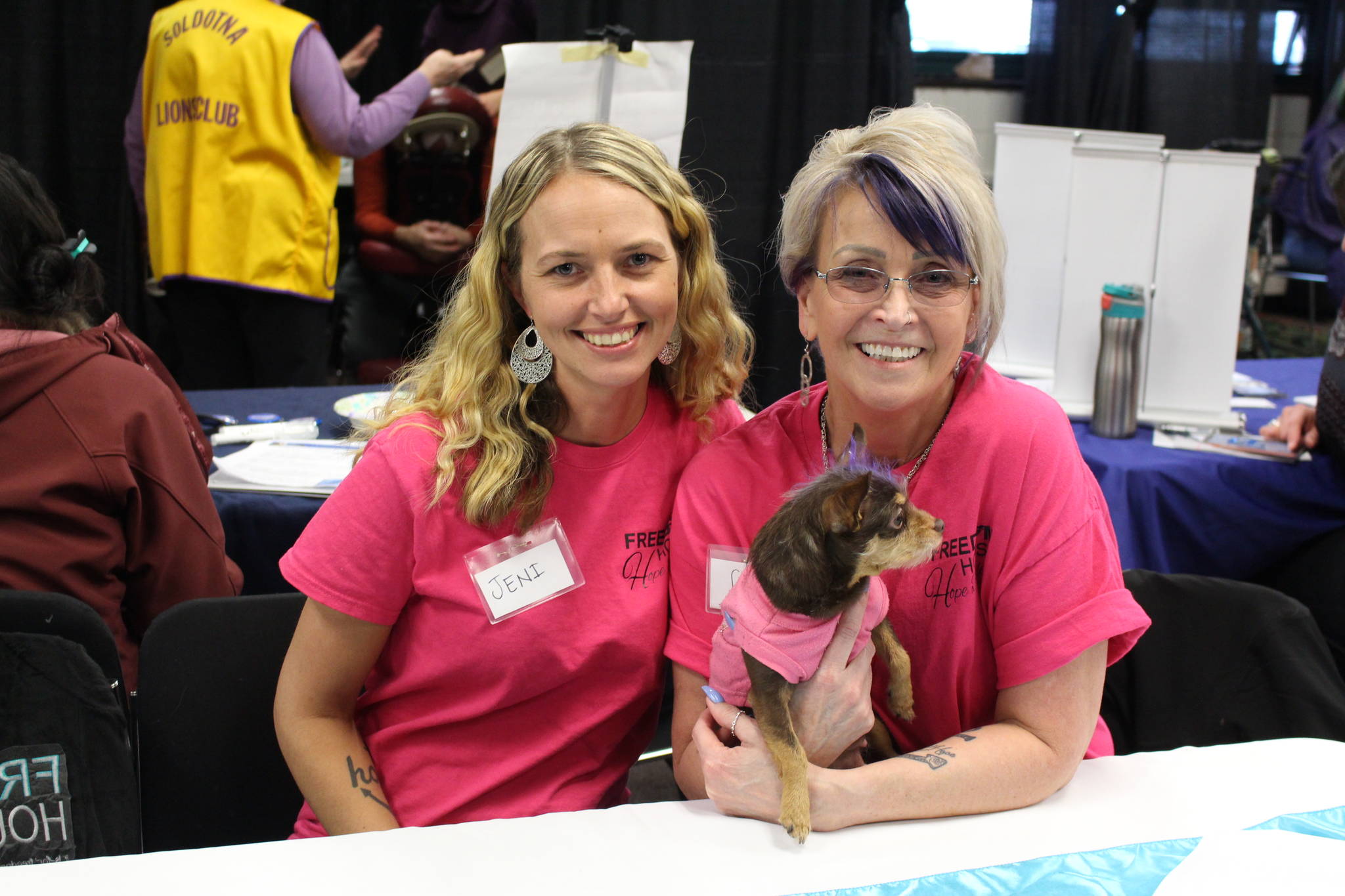 Jennifer Waller, left, Gail Kennedy, right, and Meiko the therapy dog from Freedom House attend the 2020 Project Homeless Connect event at the Soldotna Regional Sports Complex in Soldotna, Alaska, on Jan. 29, 2020. (Photo by Brian Mazurek/Peninsula Clarion)