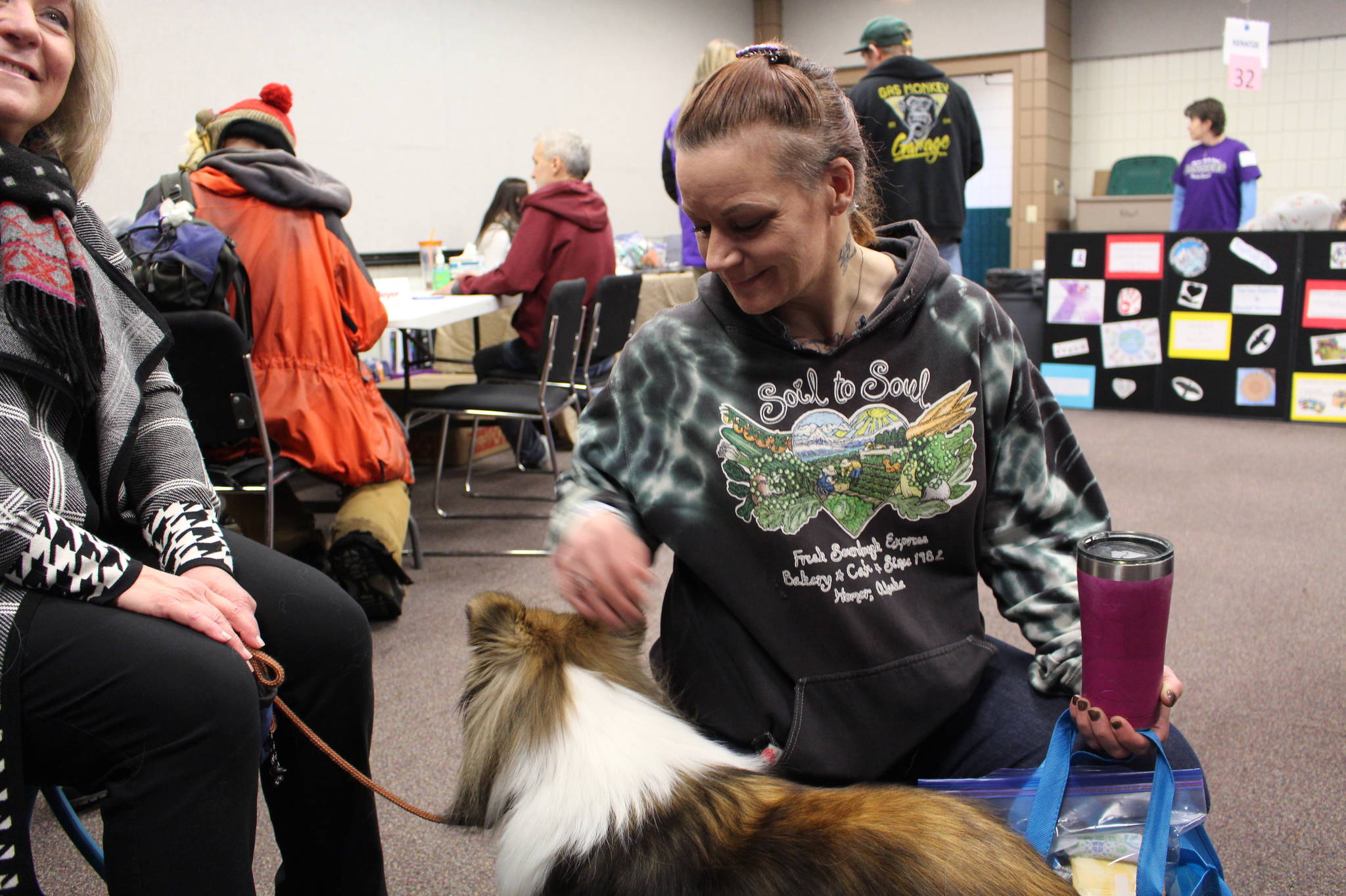 Pam Rickard visits with Collette the therapy dog during the 2020 Project Homeless Connect event at the Soldotna Regional Sports Complex in Soldotna, Alaska, on Jan. 29, 2020. (Photo by Brian Mazurek/Peninsula Clarion)