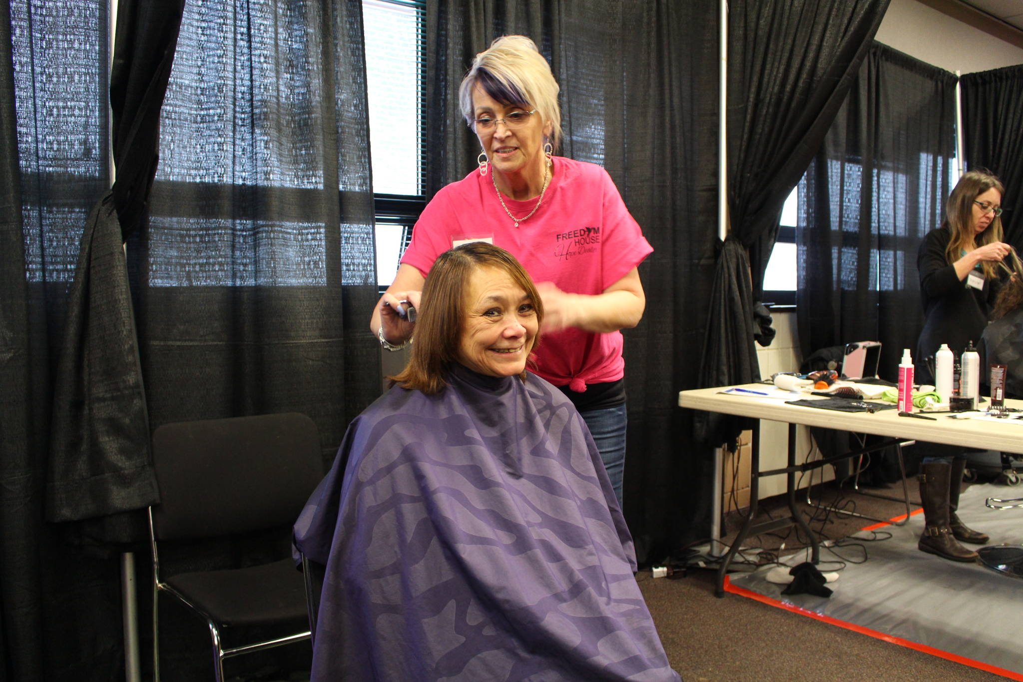 Sandra Groller gets her hair cut by Gail Kennedy of Freedom House during the 2020 Project Homeless Connect event at the Soldotna Regional Sports Complex in Soldotna, Alaska, on Jan. 29, 2020. (Photo by Brian Mazurek/Peninsula Clarion)