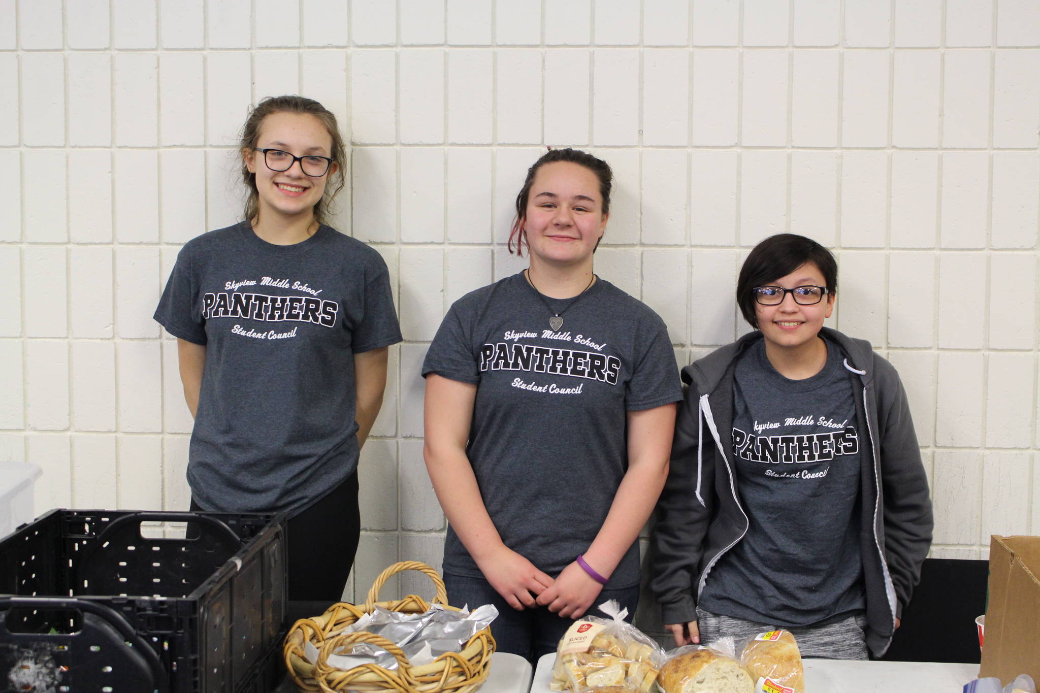 Skyview Middle School students Brooke Walters, Josie Josephson and Milo Gilliam volunteer for the food pantry during the 2020 Project Homeless Connect event at the Soldotna Regional Sports Complex in Soldotna, Alaska, on Jan. 29, 2020. (Photo by Brian Mazurek/Peninsula Clarion)