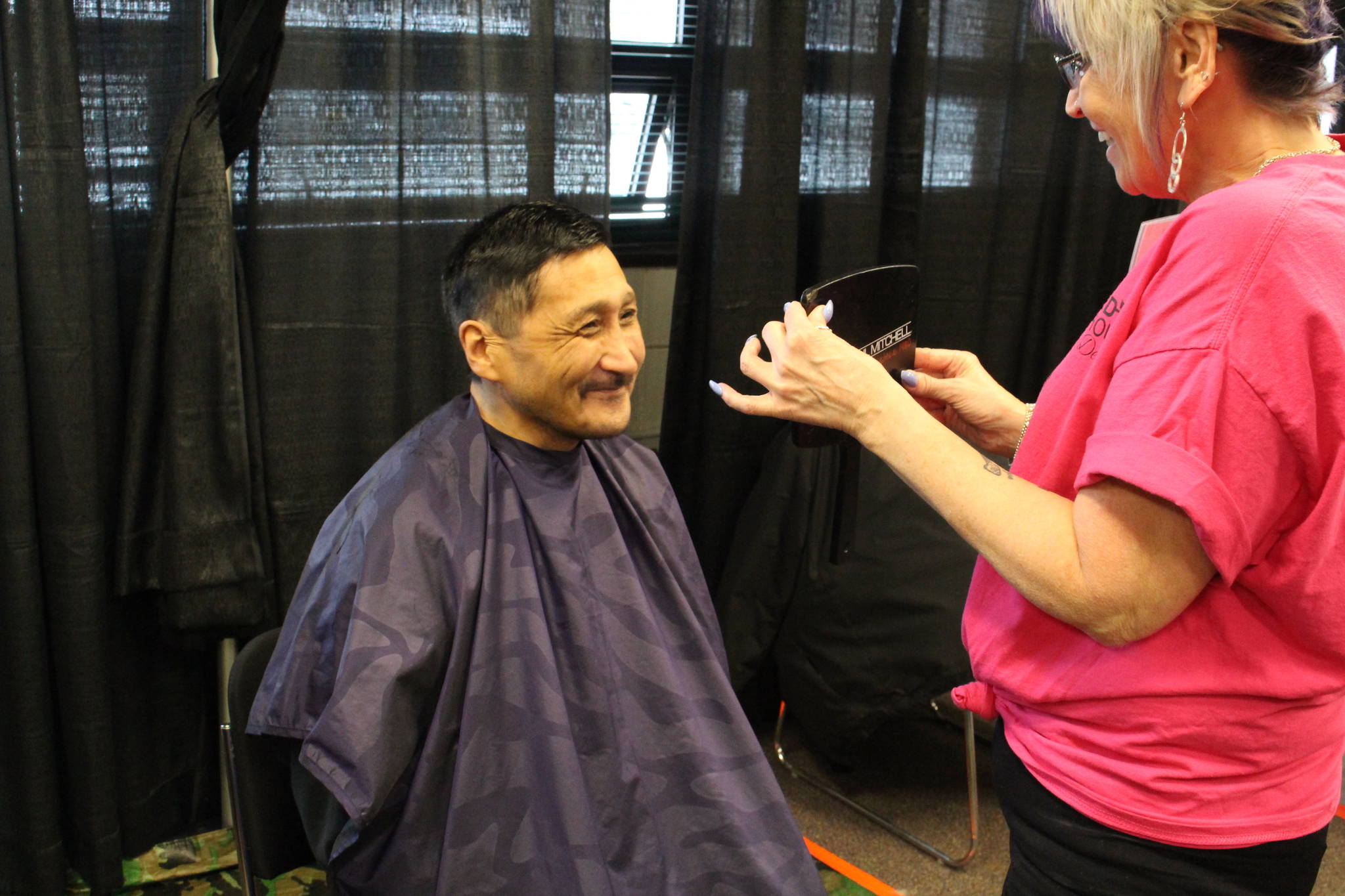 Henry Smith checks out his fresh haircut courtesy of Gail Kennedy during the 2020 Project Homeless Connect event at the Soldotna Regional Sports Complex in Soldotna, Alaska, on Jan. 29, 2020. (Photo by Brian Mazurek/Peninsula Clarion)