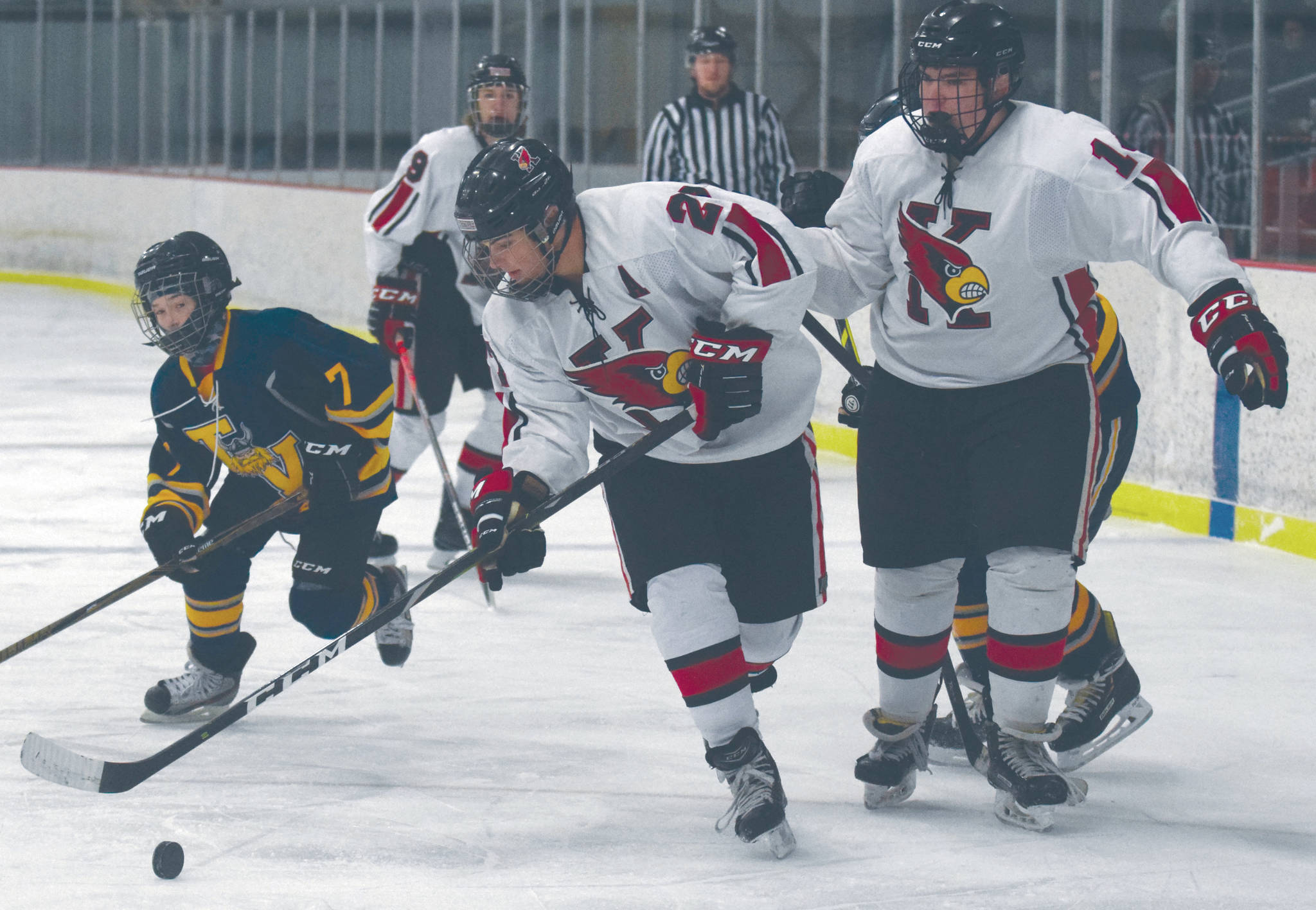 Kenai’s Nate Beiser, in front of teammate Miles Marston, keeps the puck from William Tomeo of Tri-Valley on Friday at the Kenai Multi-Purpose Facility in Kenai. (Photo by Jeff Helminiak/Peninsula Clarion)