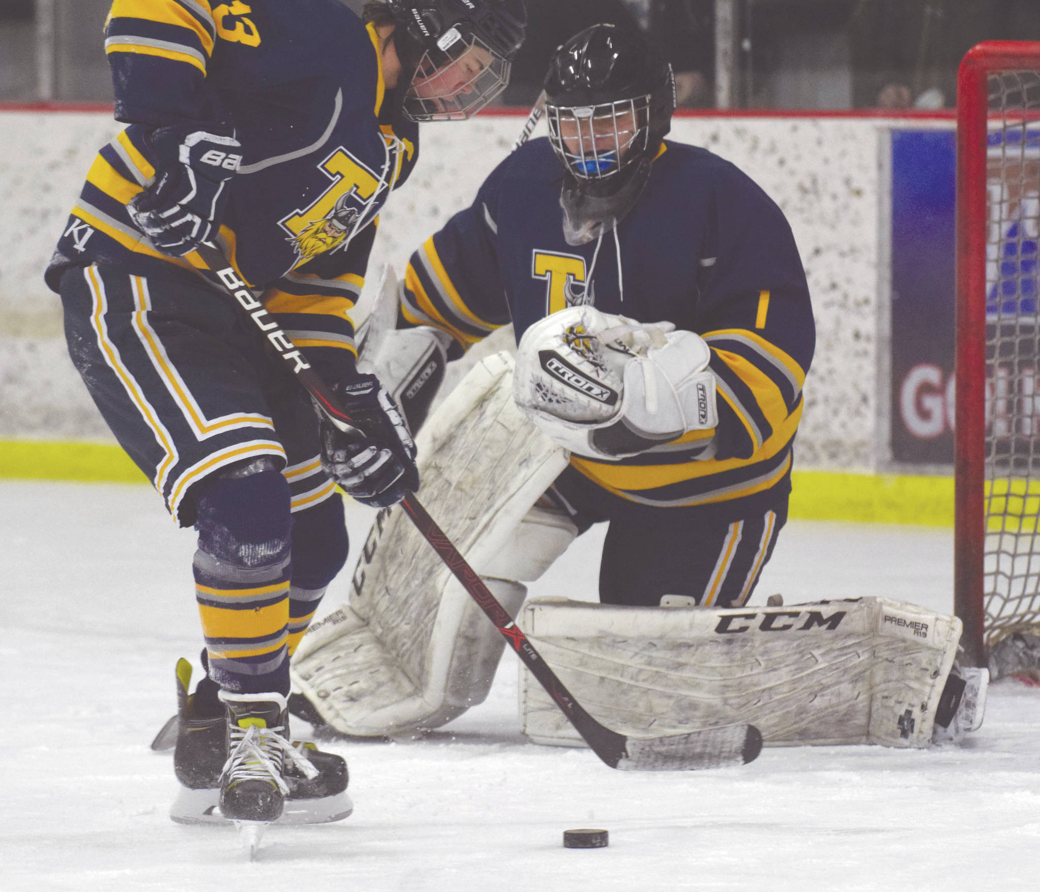 Tri-Valley’s Oliver Cole clears the puck out from in front of goalie Danny Renshaw on Friday at the Kenai Multi-Purpose Facility in Kenai. (Photo by Jeff Helminiak/Peninsula Clarion)
