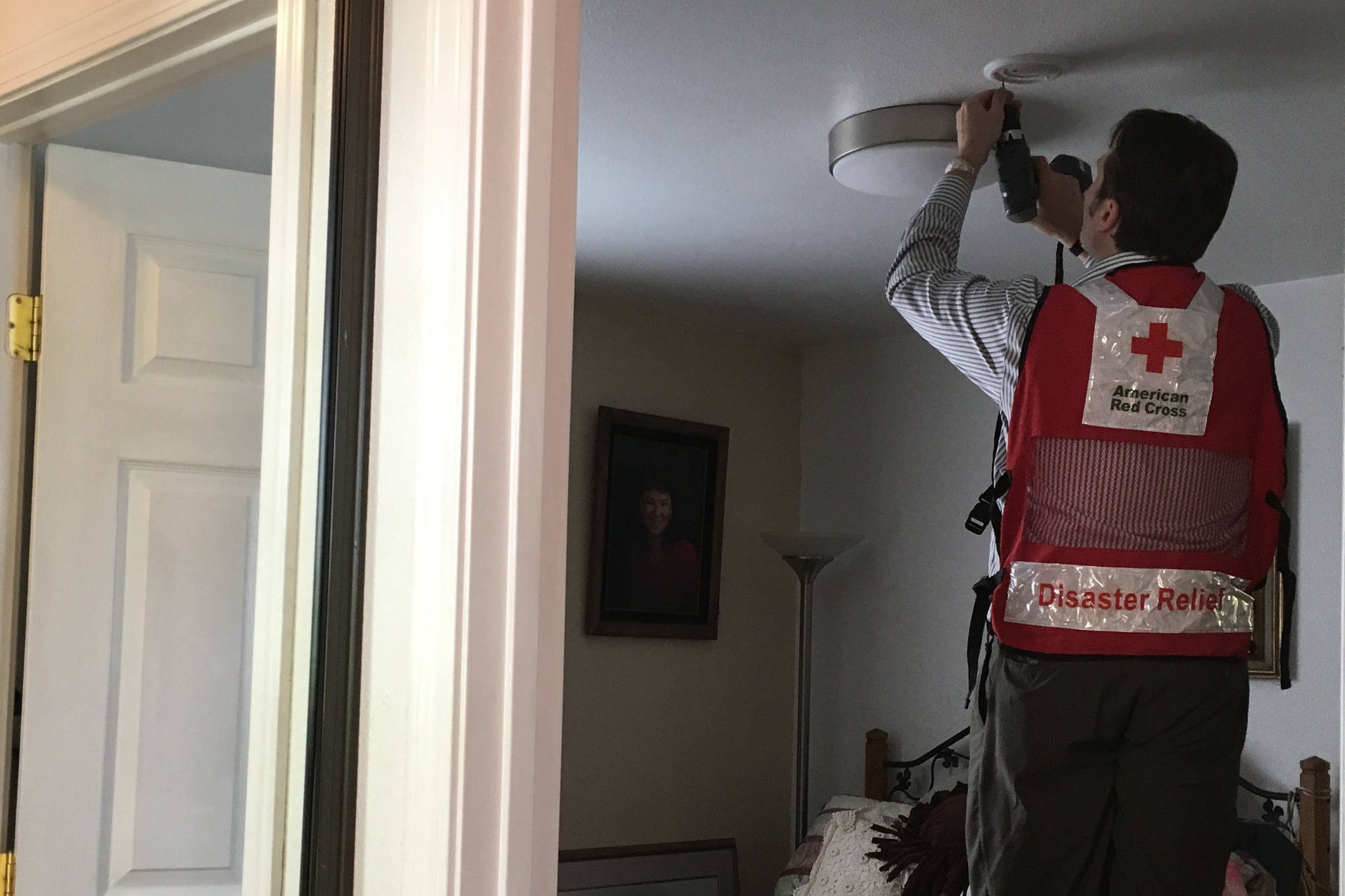 Red Cross of Alaska CEO Tanguy Libbrecht installs free, 10-year lithium battery smoke alarms at a home in Anchorage, Alaska in May 2018. (Photo courtesy Cari Dighton/Red Cross Alaska)
