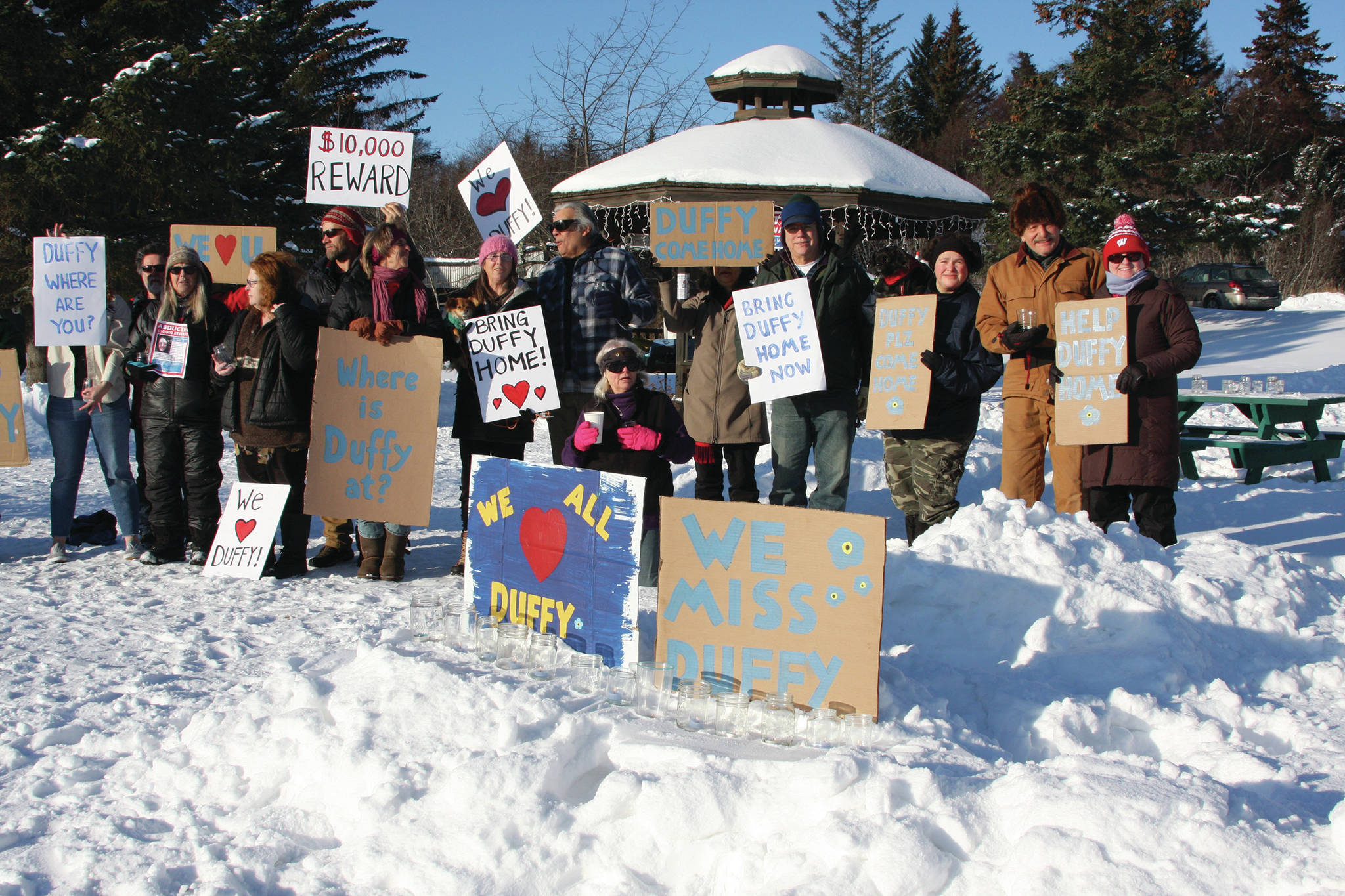 Photo by Delcenia Cosman                                Friends of Anesha “Duffy” Murnane and members of the community supporting the campaign to bring her home pose with signs during a candlelight vigil held at WKFL Park in Homer, Alaska on Feb. 1.