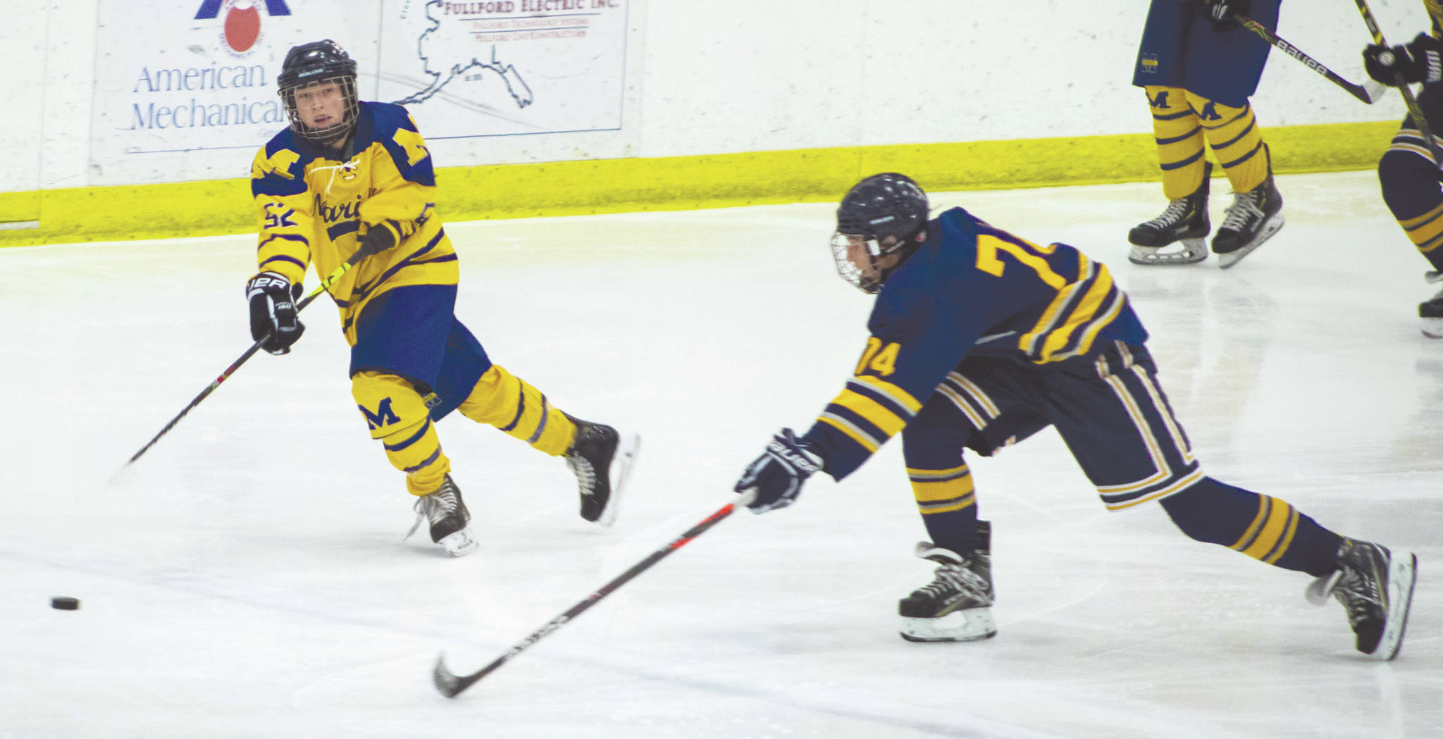 Tri-Valley’s Hayden Lusby (right) attempts to intercept a pass from Homer’s Owen Pitzman (left) in the second period of Thursday’s first round game of the Division II state hockey tournament at the Patty Center Ice Arena. The Mariners beat the Viking Warriors 13-0. (Photo by Laura Stickells/Fairbanks Daily News-Miner)