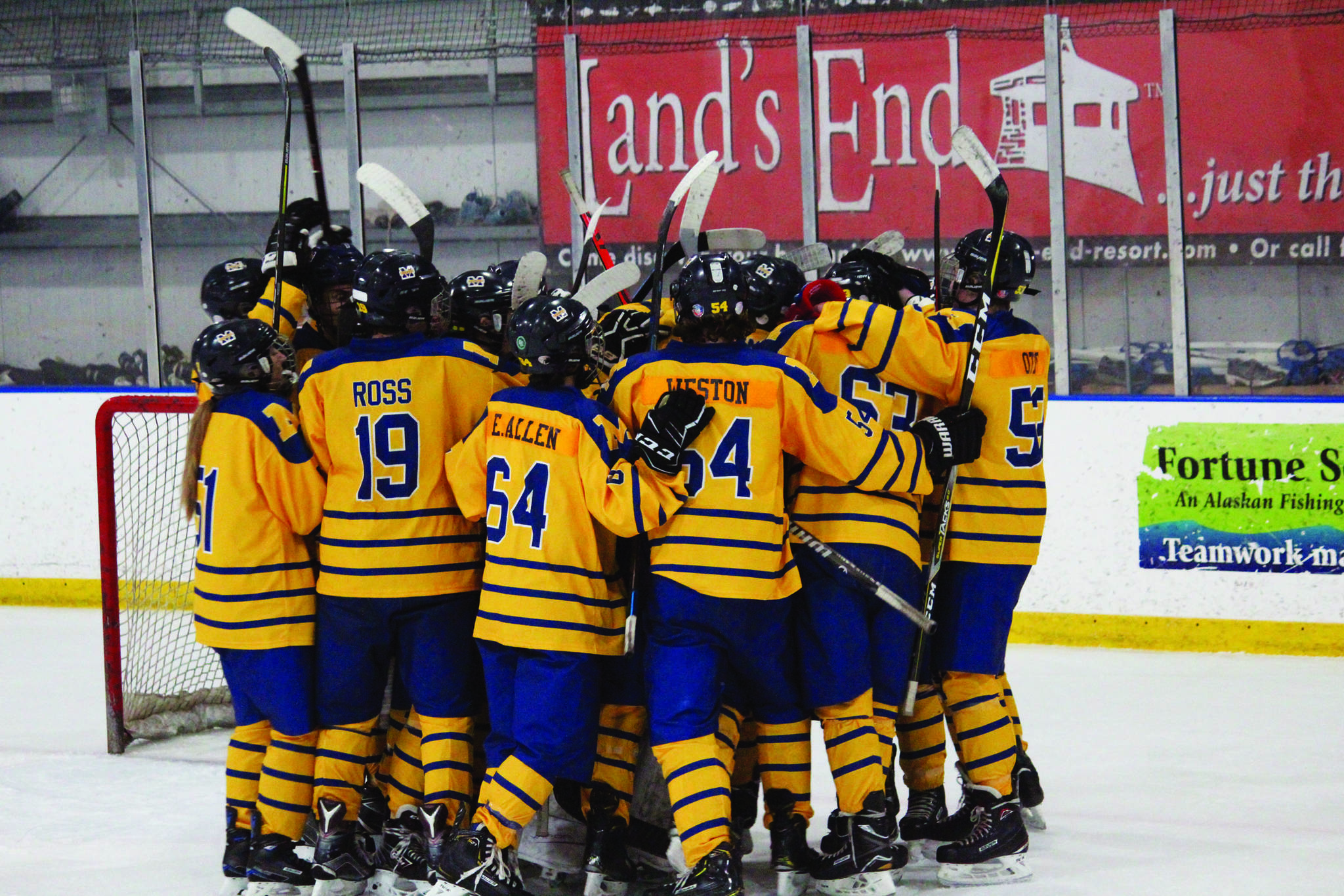 Members of the Homer hockey team swarm goalkeeper Rhodes Turner in celebration after their 7-5 loss to Colony High School on Friday, Jan. 10, 2020 at Kevin Bell Arena in Homer, Alaska. With goalie Keegan Strong out, Turner stepped in, suited up and played in the position for the very first time in a varsity game. (Photo by Megan Pacer/Homer News)