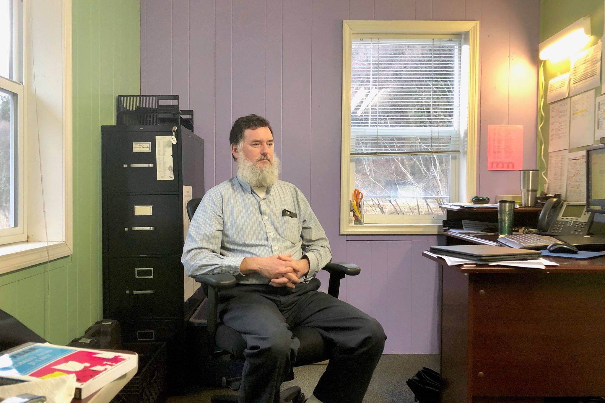 Principal Michael Wojciak sits in his office at Kachemak Selo School Nov. 12, 2019, in Kachemak Selo, Alaska. (Photo by Victoria Petersen/Peninsula Clarion)