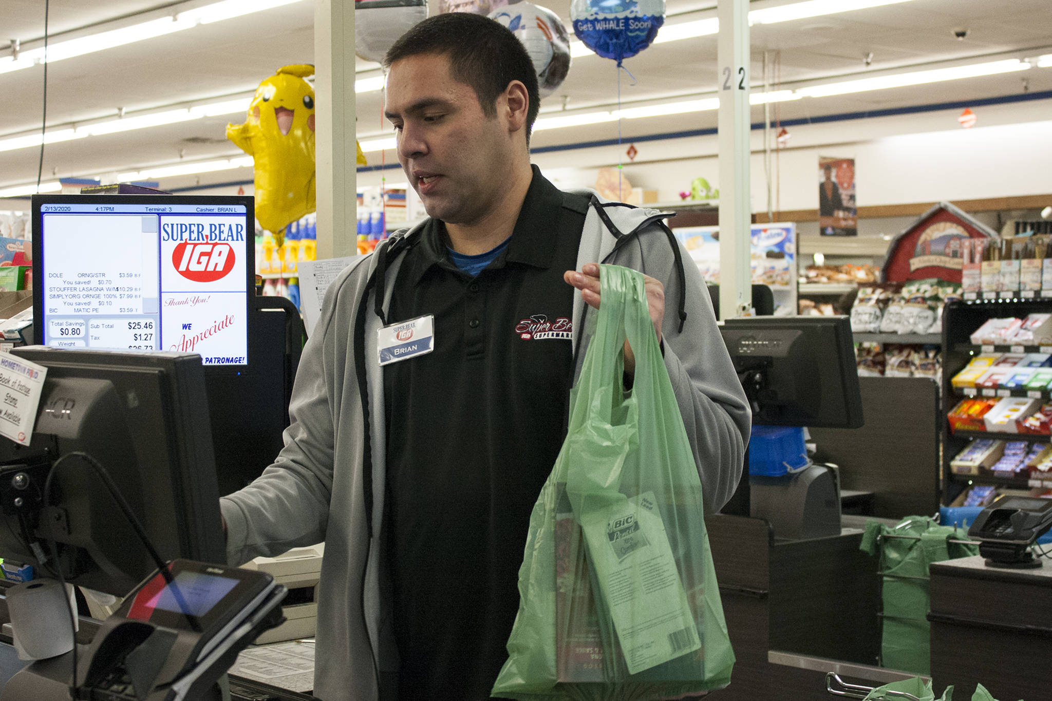 Brian Lauth, closing manager for Super Bear Supermarket IGA, bags groceries Thursday, Feb. 13, 2020. Super Bear will be collecting donations to ship food to Southeast Alaska communities impacted by a lack of ferry service. (Ben Hohenstatt | Juneau Empire)