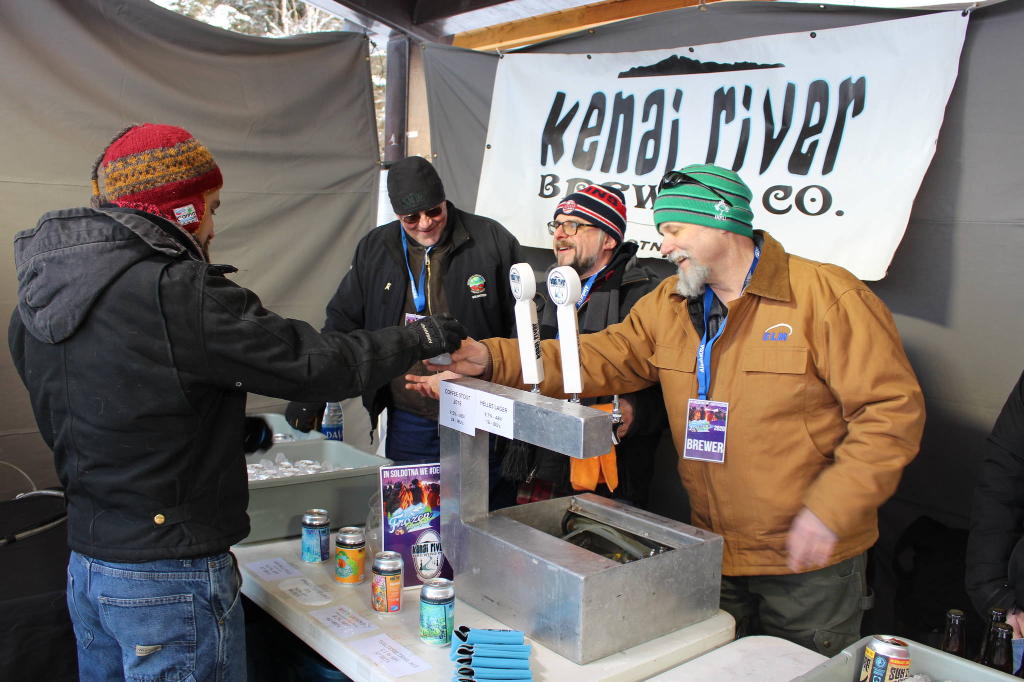 Sean Owens, right, serves up a Tsalteshi Trail Ale to Nate Mole, left, during the 2020 Frozen RiverFest at Soldotna Creek Park in Soldotna, Alaska on Feb. 15, 2020. (Photo by Brian Mazurek/Peninsula Clarion)