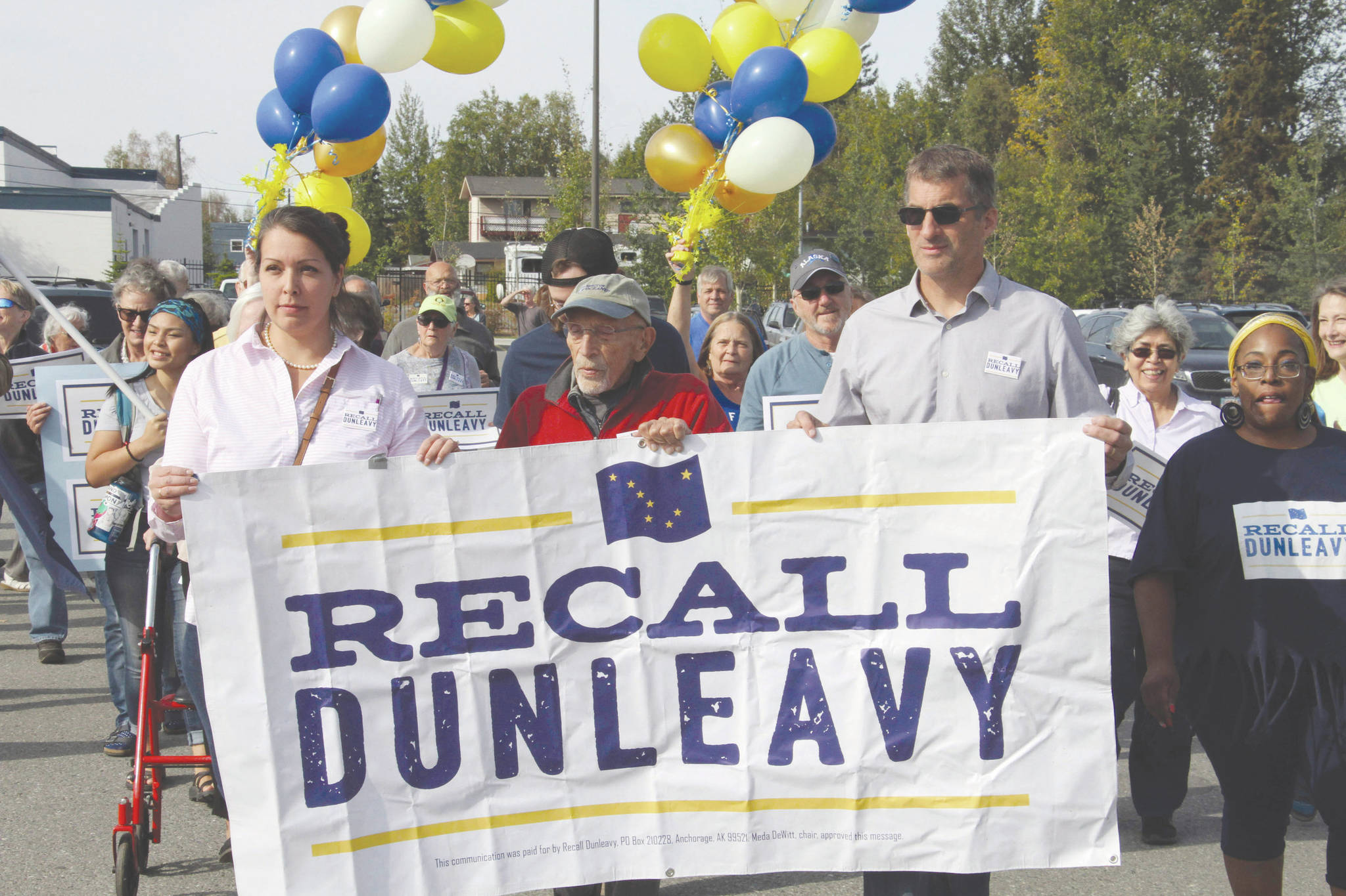 In this Sept. 5, 2019, file photo, Meda DeWitt, left, Vic Fischer, middle, and Aaron Welterlen, leaders of an effort to recall Alaska Gov. Mike Dunleavy, lead about 50 volunteers in a march to the Alaska Division of Elections office in Anchorage, Alaska. The Alaska Supreme Court on Friday, Feb. 14, 2020 agreed to allow a group seeking to recall Gov. Mike Dunleavy to begin a second signature-gathering phase. (AP Photo/Mark Thiessen, File)