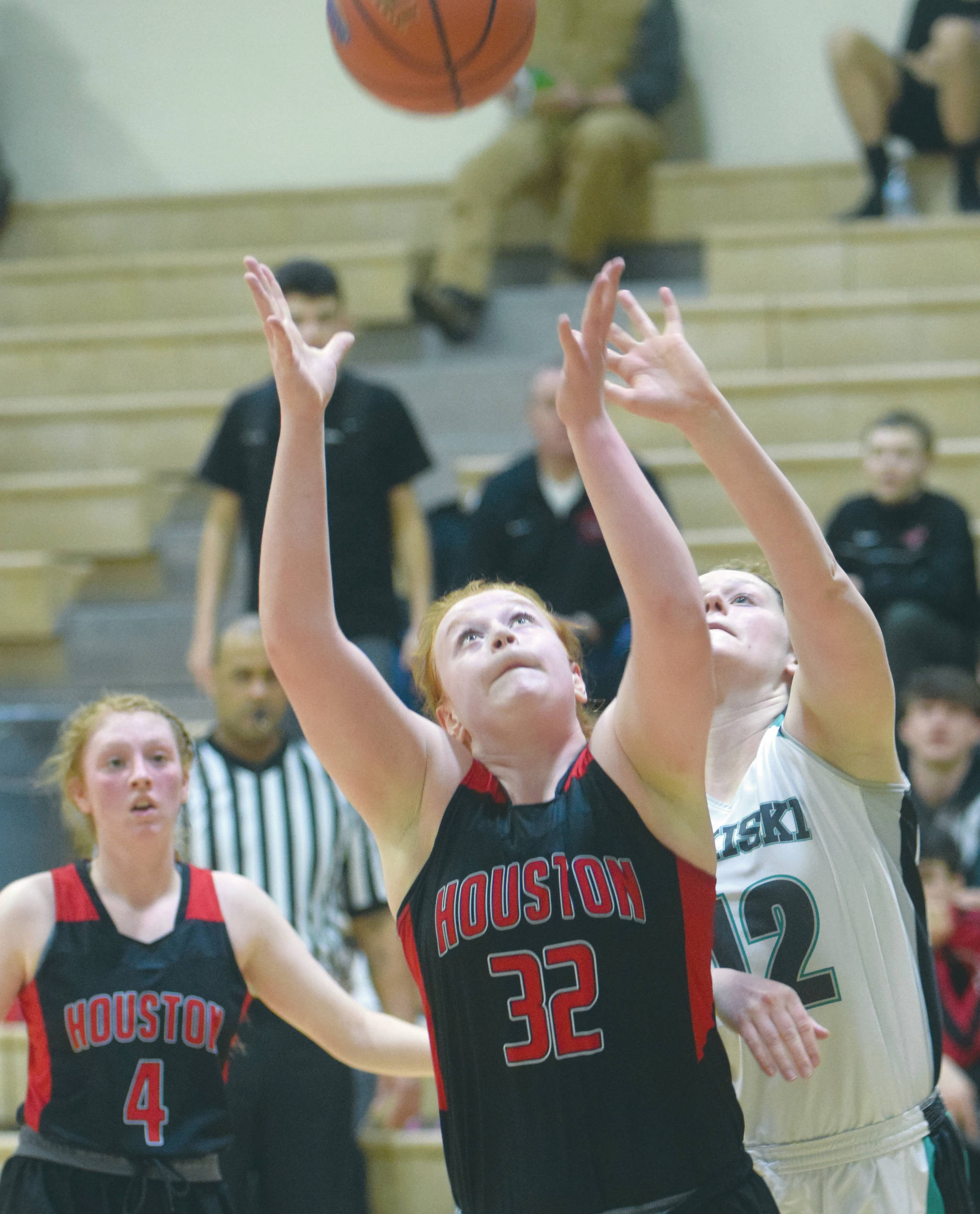 Houston’s Emily Bitler battles with Nikiski’s Kaycee Bostic for the rebound as Houston’s Denali Whitted watches Friday, Feb. 21, 2020, at Nikiski High School in Nikiski, Alaska. (Photo by Jeff Helminiak/Peninsula Clarion)