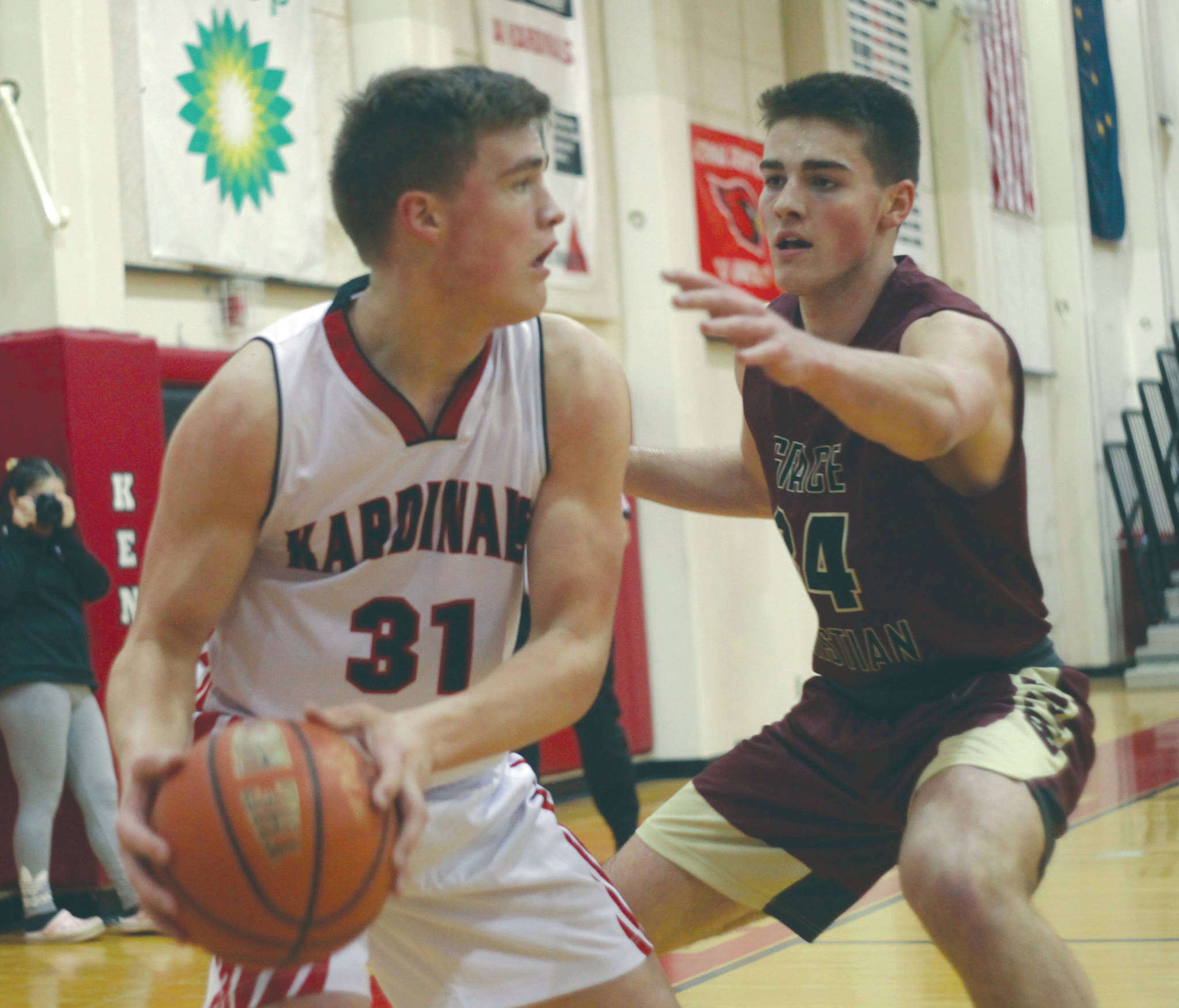 Kenai’s Braedon Pitsch passes under pressure from Grace Christian’s Andrew Beck on Friday, Feb. 22, 2020, at Kenai Central High School in Kenai, Alaska. (Photo by Ben Boettger/Peninsula Clarion)