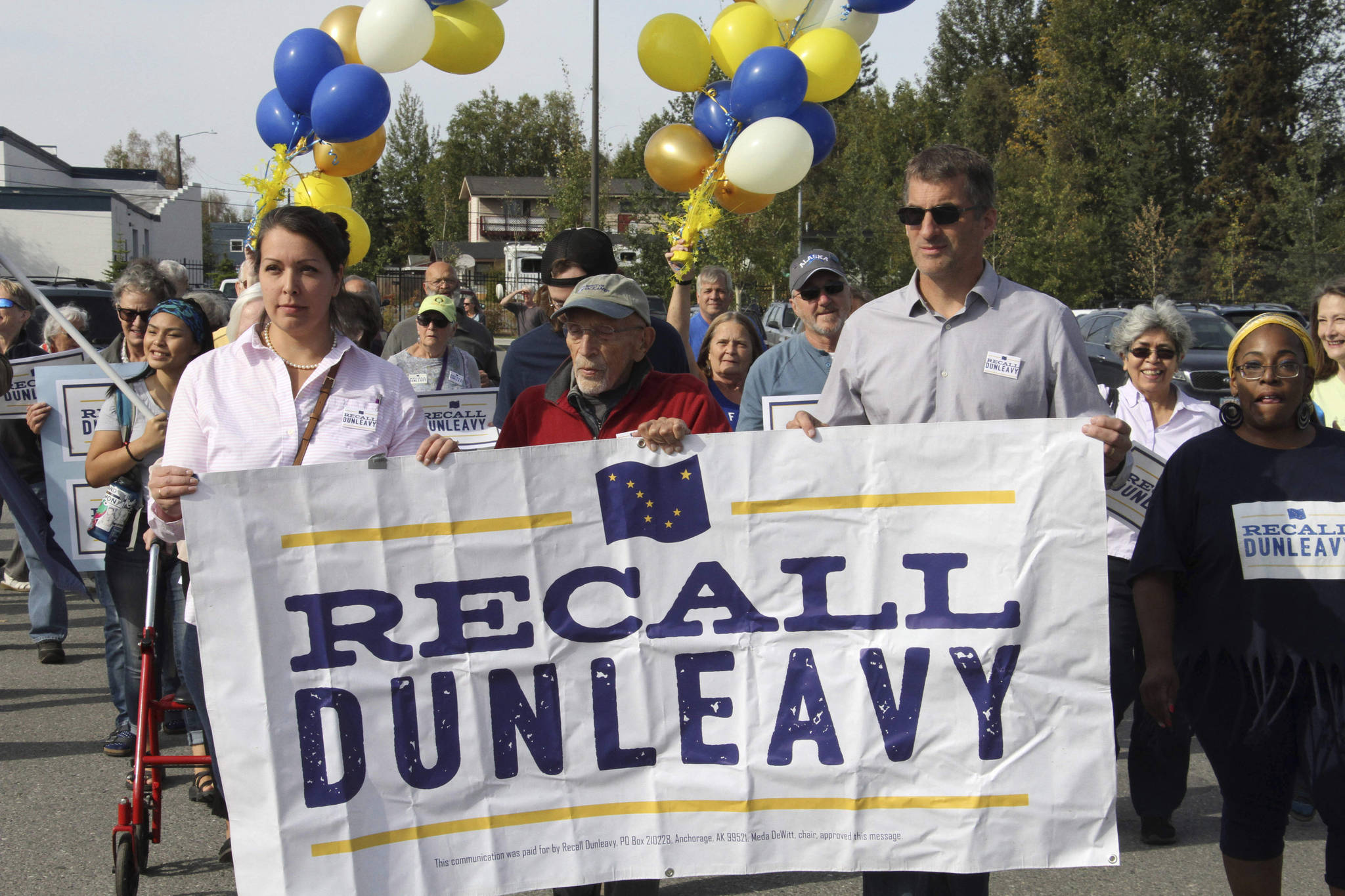 In this Sept. 5, 2019, file photo, Meda DeWitt, left, Vic Fischer, middle, and Aaron Welterlen, leaders of an effort to recall Alaska Gov. Mike Dunleavy, lead about 50 volunteers in a march to the Alaska Division of Elections office in Anchorage, Alaska. The Alaska Supreme Court on Friday, Feb. 14, 2020 agreed to allow a group seeking to recall Gov. Mike Dunleavy to begin a second signature-gathering phase. (AP Photo/Mark Thiessen, File)