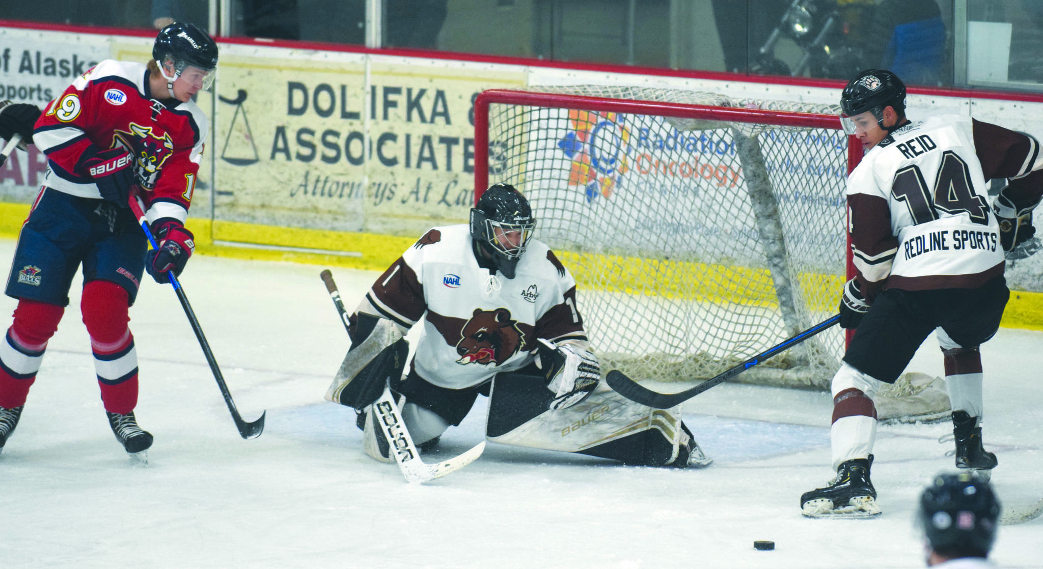 Kenai River goalie Landon Pavlisin defends the net from Amarillo (Texas) Bulls forward Niclas Puikkonen as Kenai River’s Ryan Reid looks on Friday, March 6, 2020, at the Soldotna Regional Sports Complex in Soldotna, Alaska. (Photo by Jeff Helminiak/Peninsula Clarion)