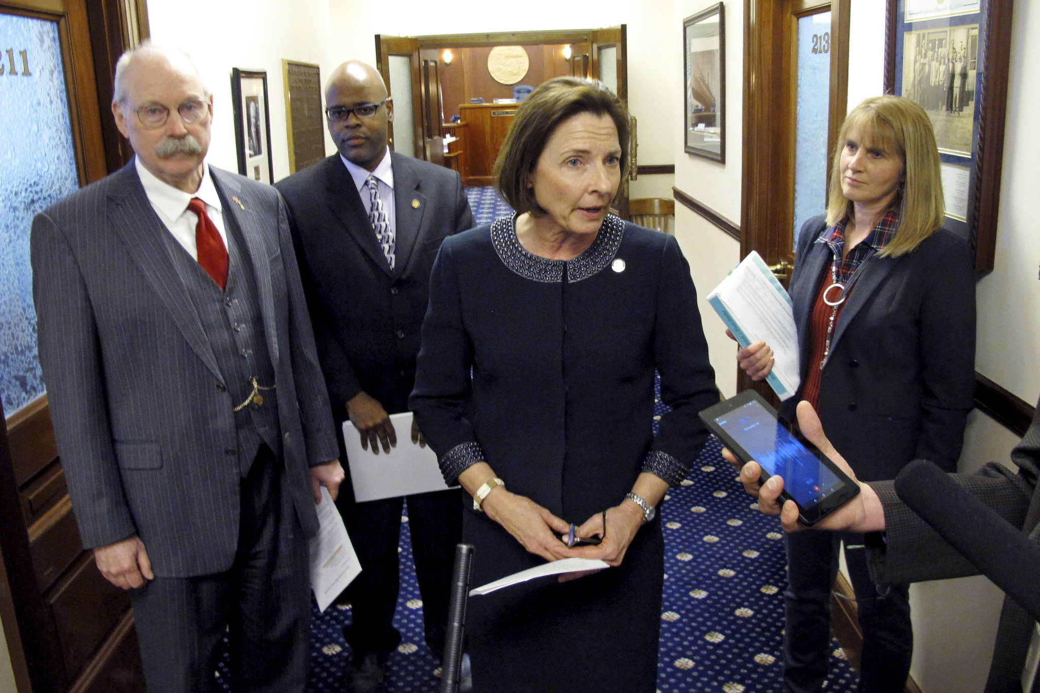 Alaska Senate President Cathy Giessel speaks to reporters after the Senate approved funding for the state to respond to the new coronavirus on Wednesday, March 11, 2020, in Juneau, Alaska. Also pictured, from left, are Sens. Bert Stedman, David Wilson and Natasha von Imhof. (AP Photo/Becky Bohrer)