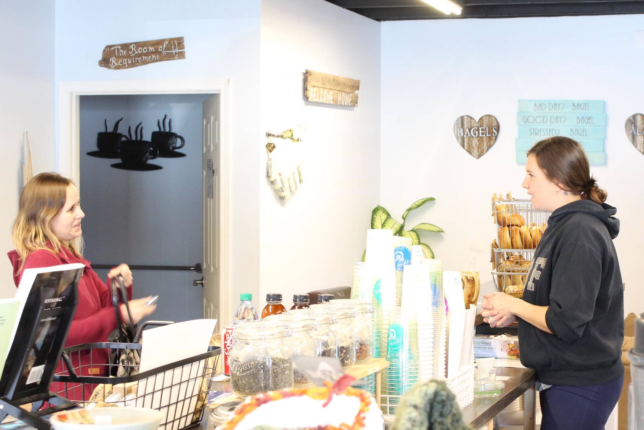 Everything Bagels owner Pamela Parker, right, takes an order from Jenna Evans, left, while maintaining social distancing at Everything Bagels in Soldotna, Alaska, on March 18, 2020. (Photo by Brian Mazurek/Peninsula Clarion)