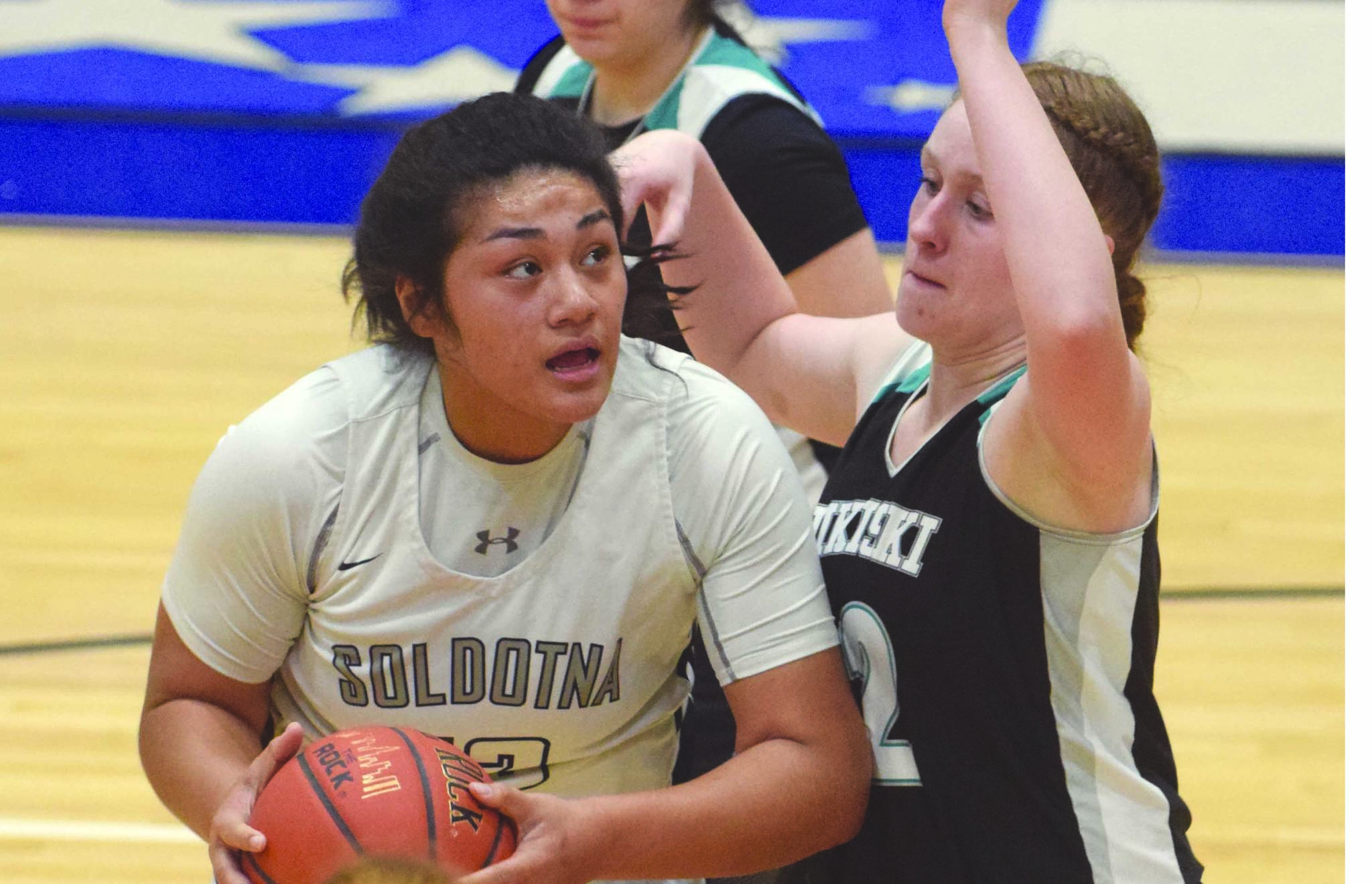 Soldotna’s Ituau Tuisaula powers up against Nikiski’s Kaycee Bostic on Tuesday, Jan. 21, 2020, at Soldotna High School in Soldotna, Alaska. (Photo by Jeff Helminiak/Peninsula Clarion)