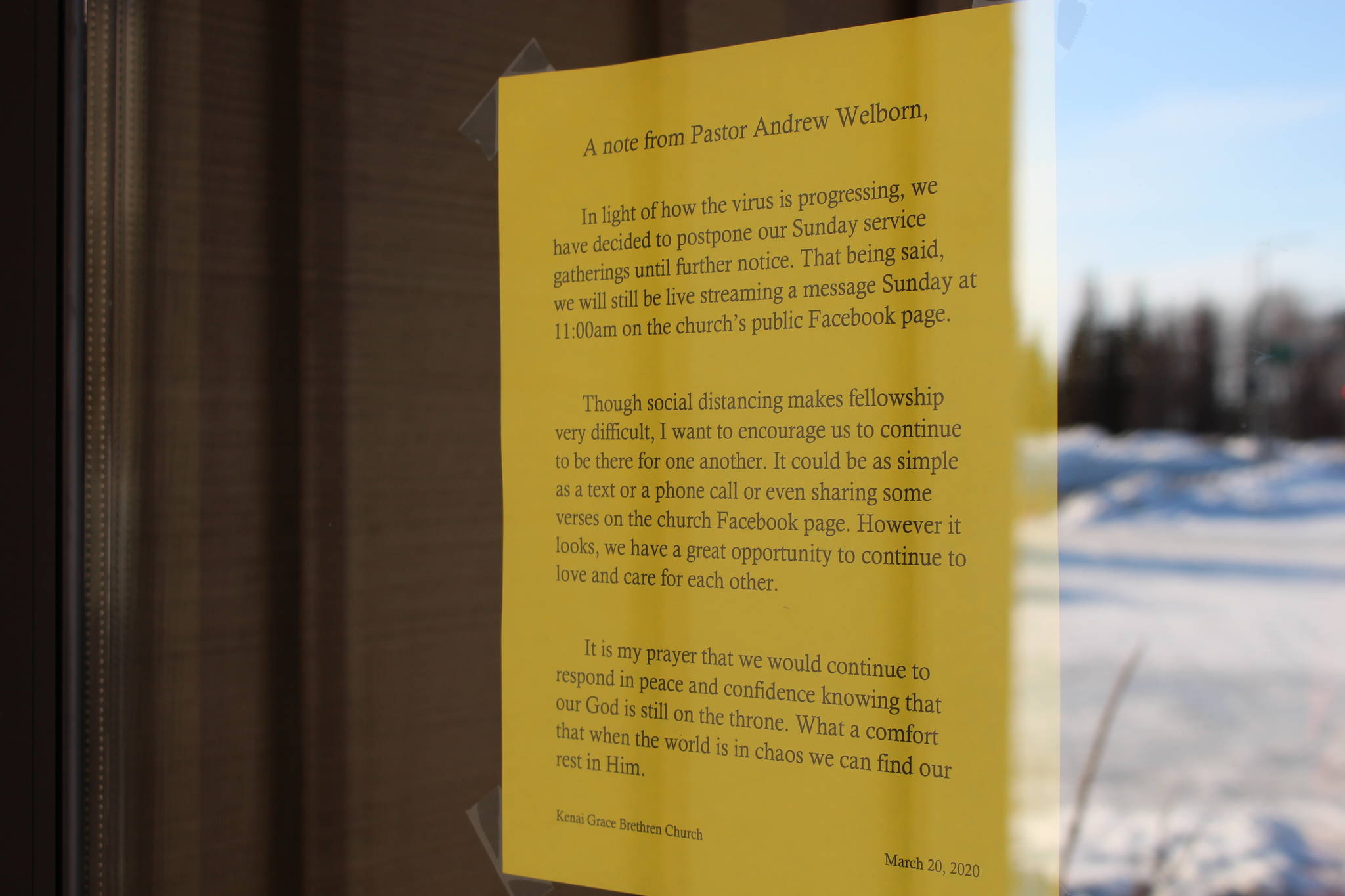 A sign on the door of Kenai Grace Brethren Church indicating that in-person Sunday gatherings have been postponed is seen here in Kenai, Alaska, on March 28, 2020. (Photo by Brian Mazurek/Peninsula Clarion)