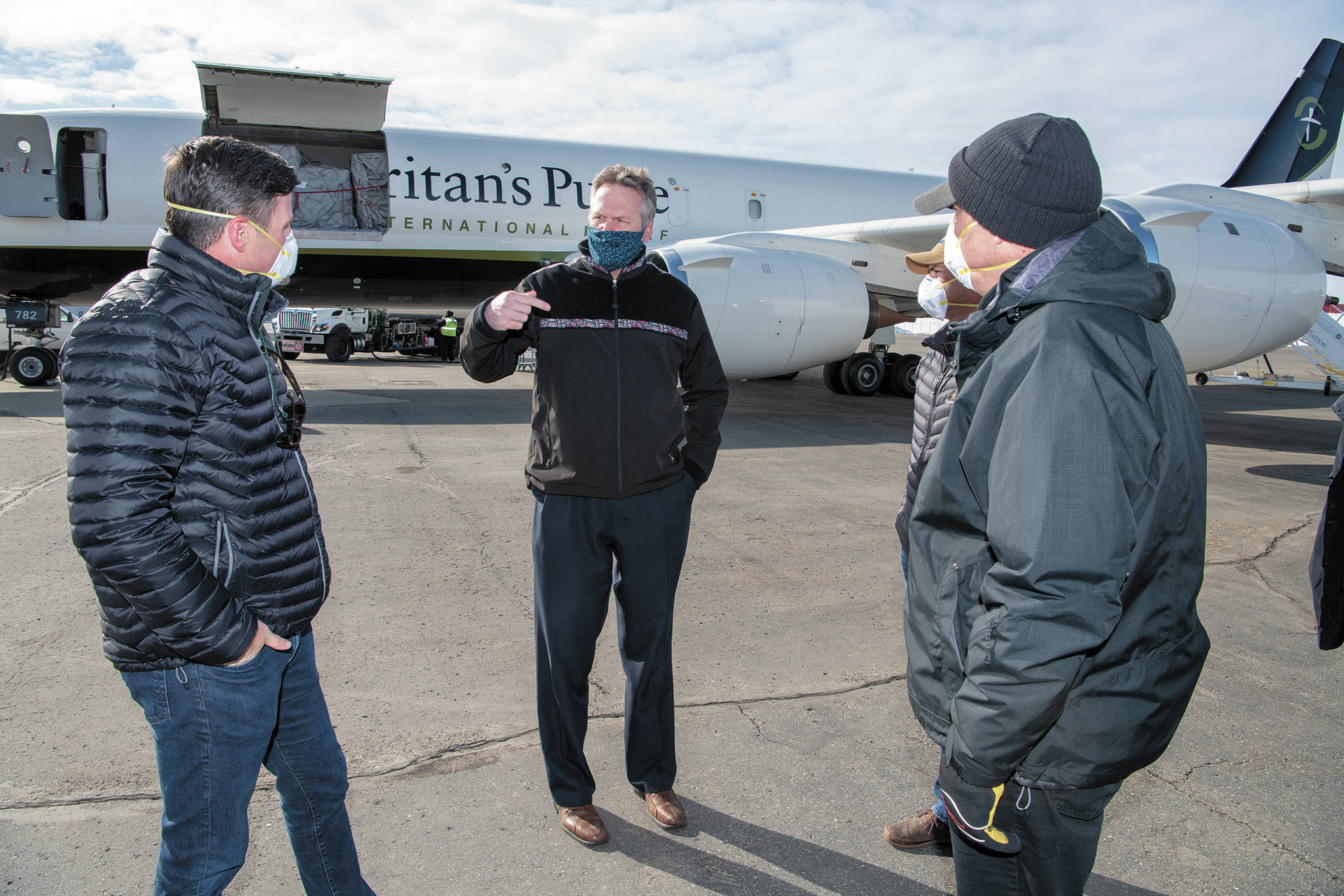 Photo courtesy Office of the Governor                                Gov. Mike Dunleavy (center) speaks with Edward Graham (left) of Samaritan’s Purse, as two other Samaritan’s Purse staff members watch. Dunleavy met the crew and staff of the Samaritan’s Purse DC-8 at Ted Stevens Anchorage International Airport as they offloaded thousands of pounds of medical supplies bound for rural Alaska.
