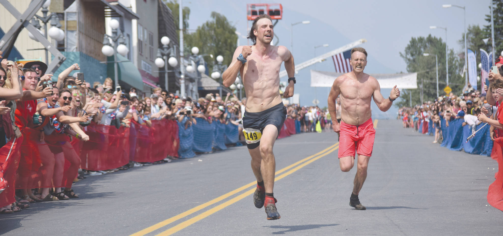 Jeff Helminiak / Peninsula Clarion file                                 Pyper Dixon and Erik Johnson, both of Seward, sprint for the finish of the Mount Marathon Race on July 4, 2019, in Seward.