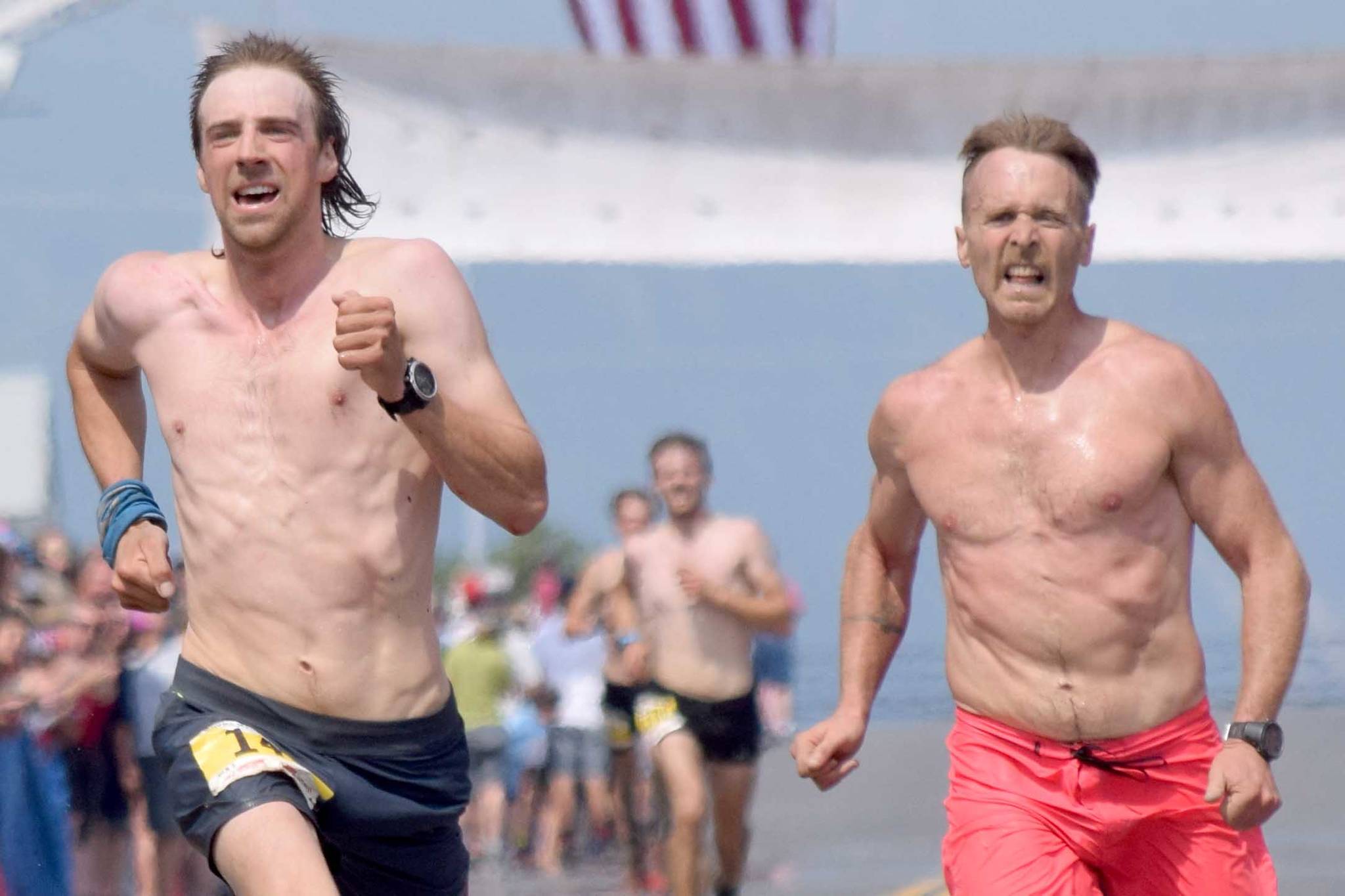 Pyper Dixon and Erik Johnson, both of Seward, sprint for the finish of the Mount Marathon Race on Thursday, July 4, 2019, in Seward, Alaska. (Photo by Jeff Helminiak/Peninsula Clarion)