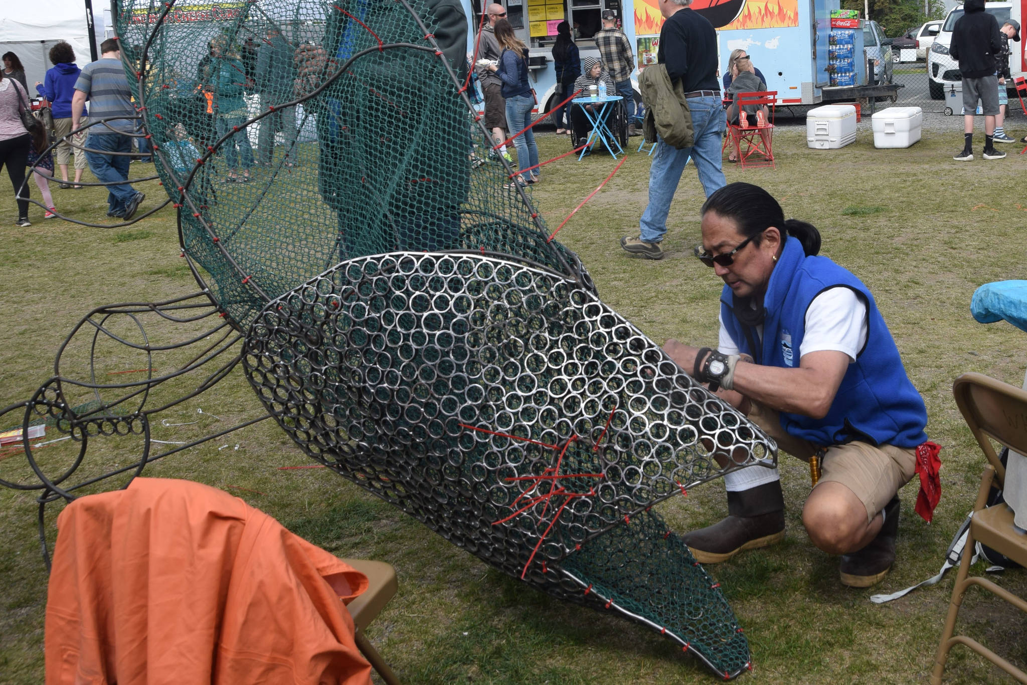 photos by Brian Mazurek / Peninsula Clarion                                 Cam Choy, Associate Professor of Art at Kenai Peninsula College, works on a salmon sculpture in collaboration with the Kenai Watershed Forum during the Kenai River Festival at Soldotna Creek Park in Soldotna on June 8, 2019.