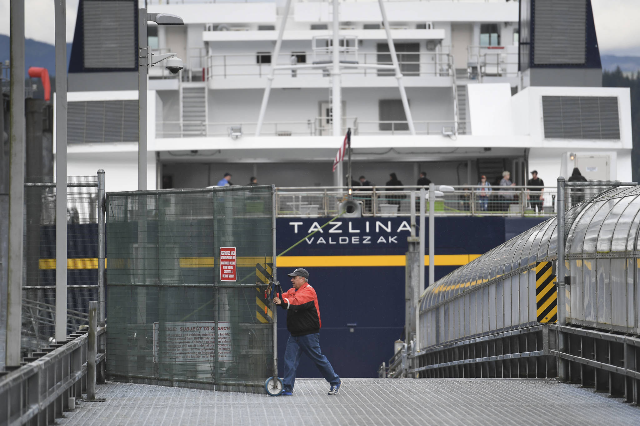 The Alaska Marine Highway System employee opens the vehicle gate after the Tazlina arrives at the Auke Bay Terminal in July 2019. (Michael Penn | Juneau Empire File)