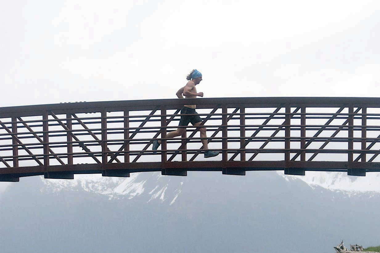 Pyper Dixon crosses a bridge during the Dixon/Holden Memorial Tonsina Beach Trail Run on Wednesday, May 31, 2018, in the Caines Head State Recreation Area in Seward. (Photo by Jeff Helminiak/Peninsula Clarion)