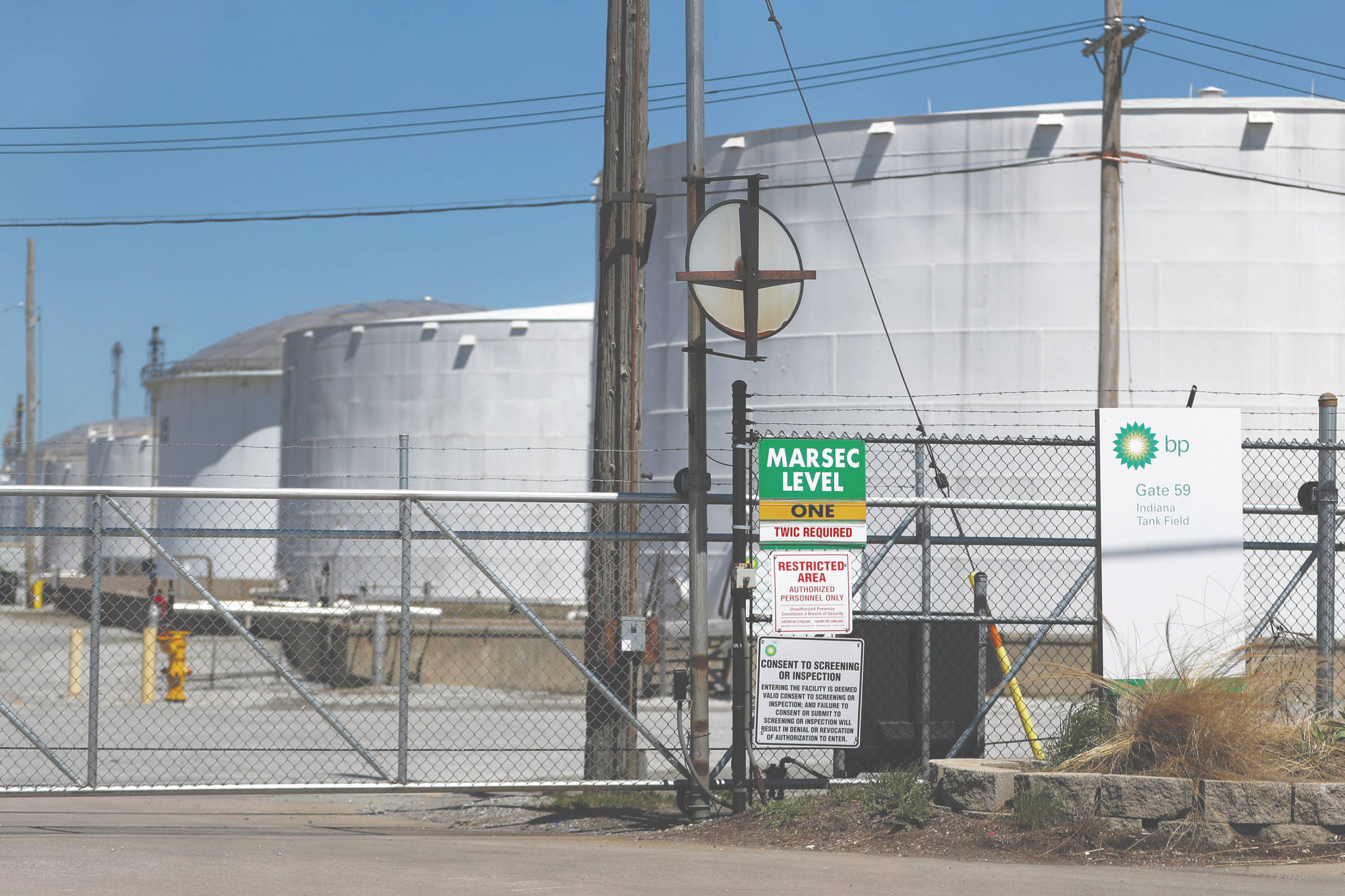 Charles Rex Arbogast / associated press                                 Petroleum storage tanks at the BP Indiana Tank Field are seen behind a security gate Tuesday in Whiting, Indiana. The world is awash in oil, there’s little demand for it and we’re running out of places to put it