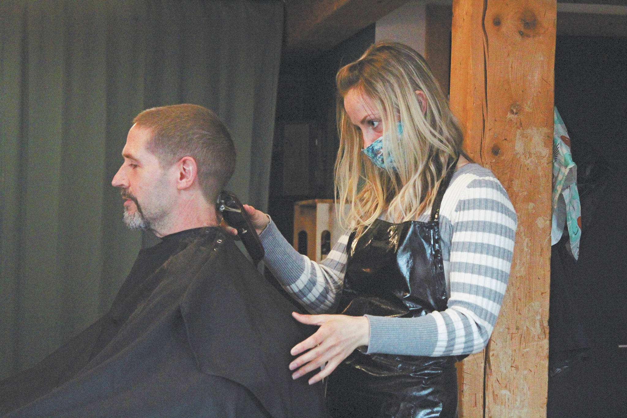 Ashley Story gives a haircut to client Michael Halstead on Friday at her salon Short Cuts on Lake Street in Homer, Alaska. Story’s is one of several Homer businesses to reopen their doors Friday according to relaxed state restrictions, while several others have opted to wait. (Photo by Megan Pacer/Homer News)